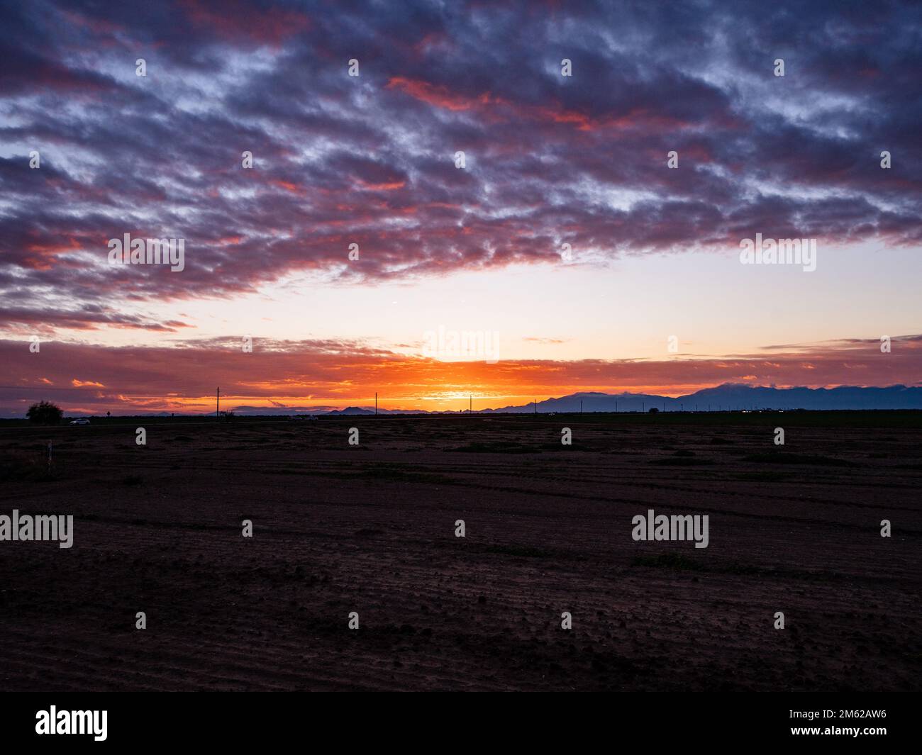 Un coucher de soleil d'hiver lumineux dans le désert de l'Arizona projette de multiples teintes vives sur les nuages ainsi que sur le paysage Banque D'Images