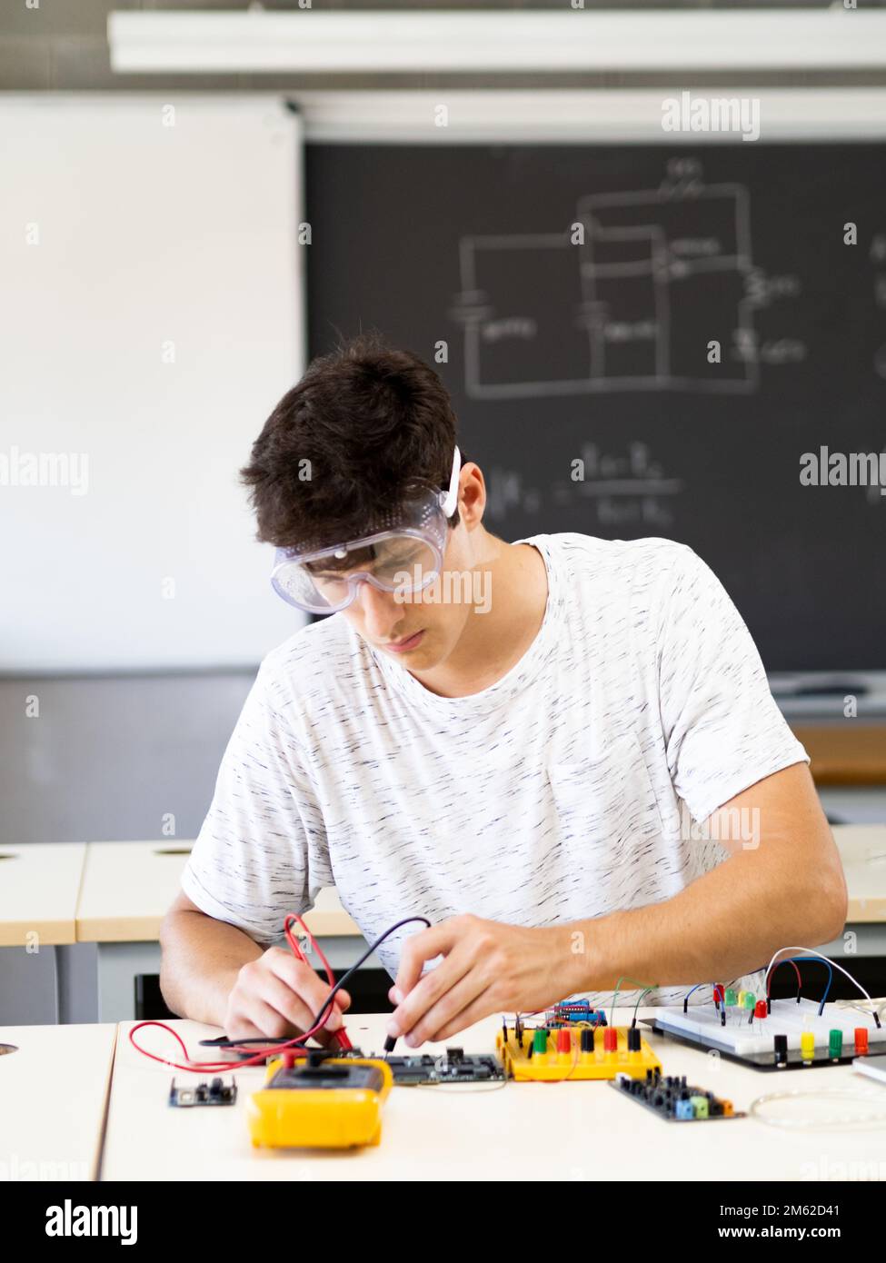 Jeune étudiant expérimenté avec des appareils électroniques dans le laboratoire Banque D'Images