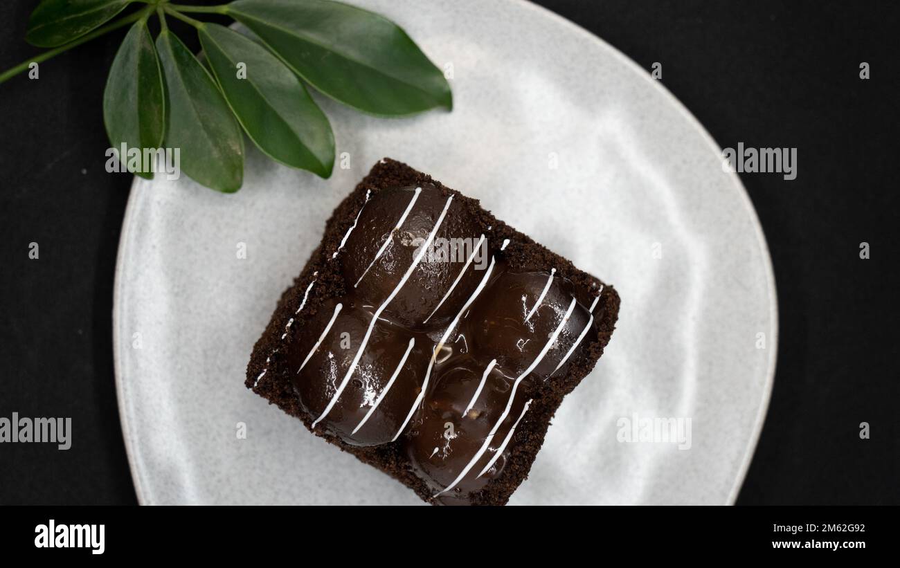 gâteau au chocolat avec crème et noix sur fond noir Banque D'Images