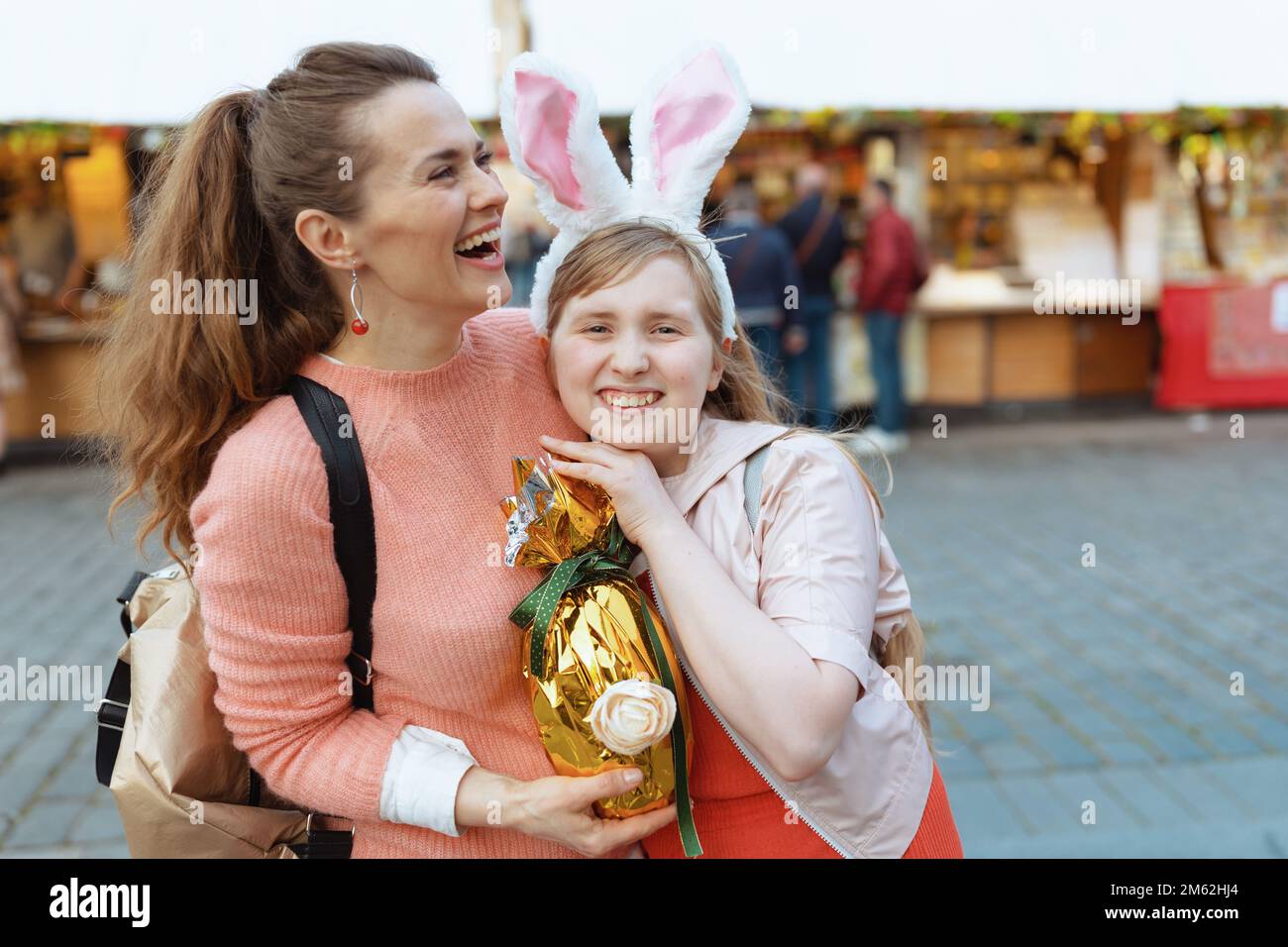 Pâques amusant. bonne mère moderne et fille adolescente avec oeuf de pâques doré à la foire dans la ville. Banque D'Images