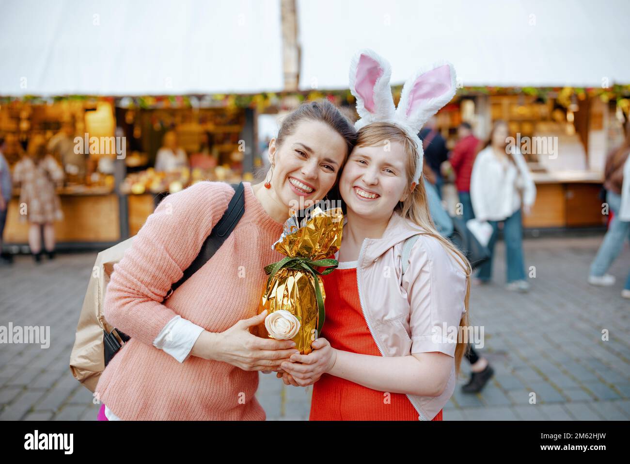 Pâques amusant. bonne jeune mère et fille adolescente avec oeuf de pâques doré à la foire dans la ville. Banque D'Images