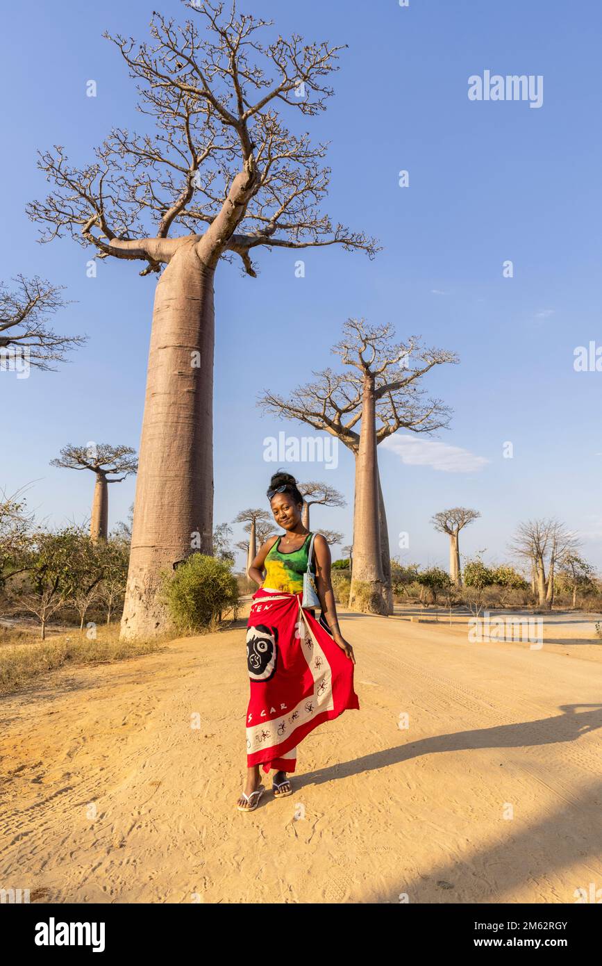 Femme en robe malgache traditionnelle posant sur l'avenue des Baobabs à Morondava, Madagascar, Afrique Banque D'Images