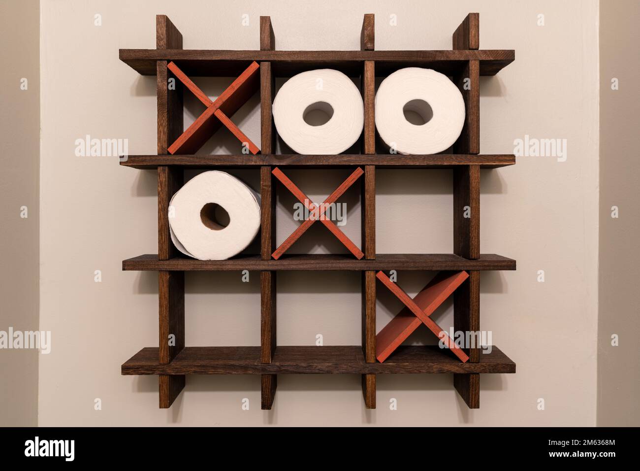 Une étagère en bois TIC-TAC-TOE pour rouleaux de papier toilette. Décoration des toilettes. Nughts et croix, X et OS. Banque D'Images
