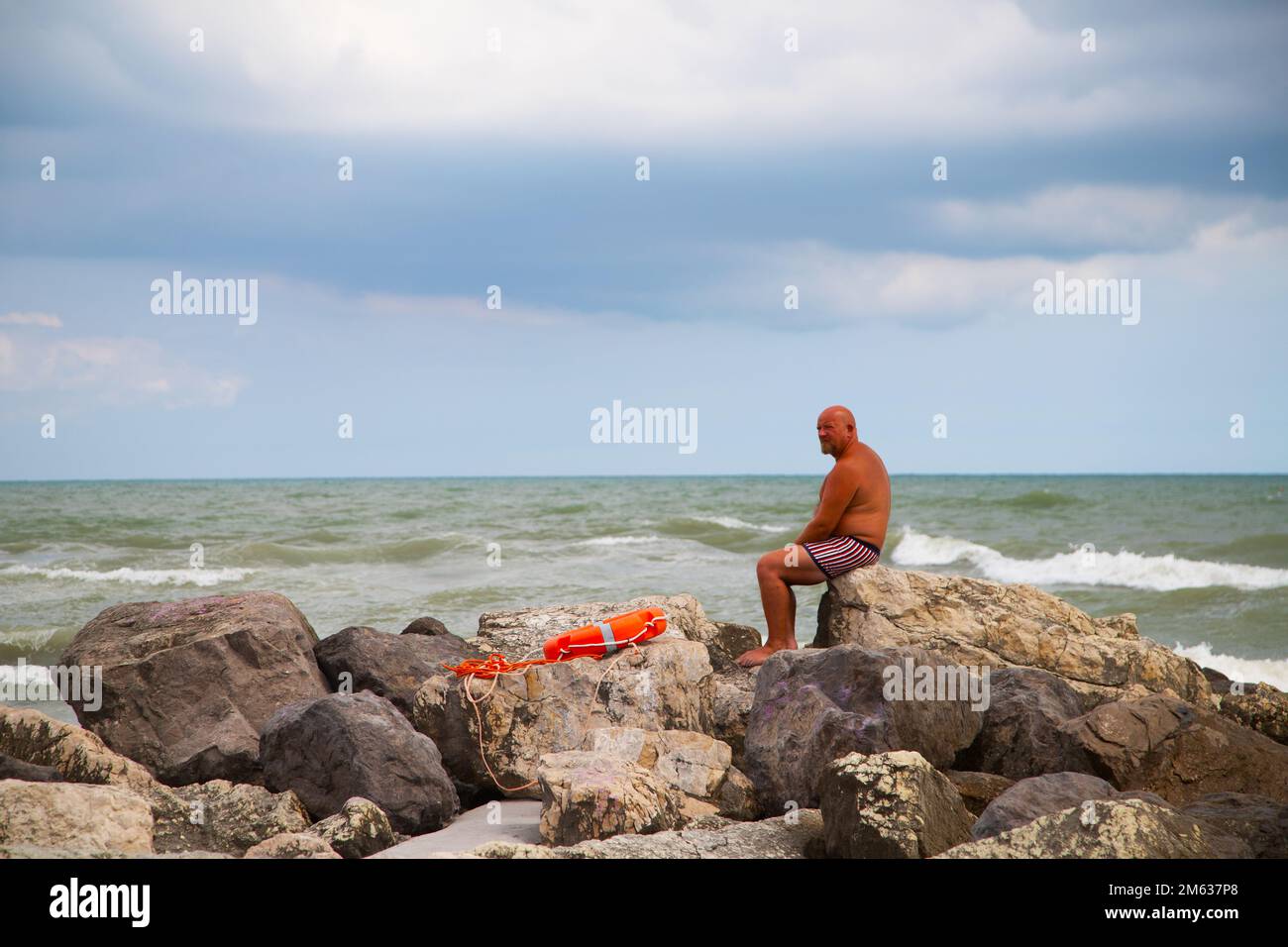 Homme regardant la mer depuis les rochers Banque D'Images