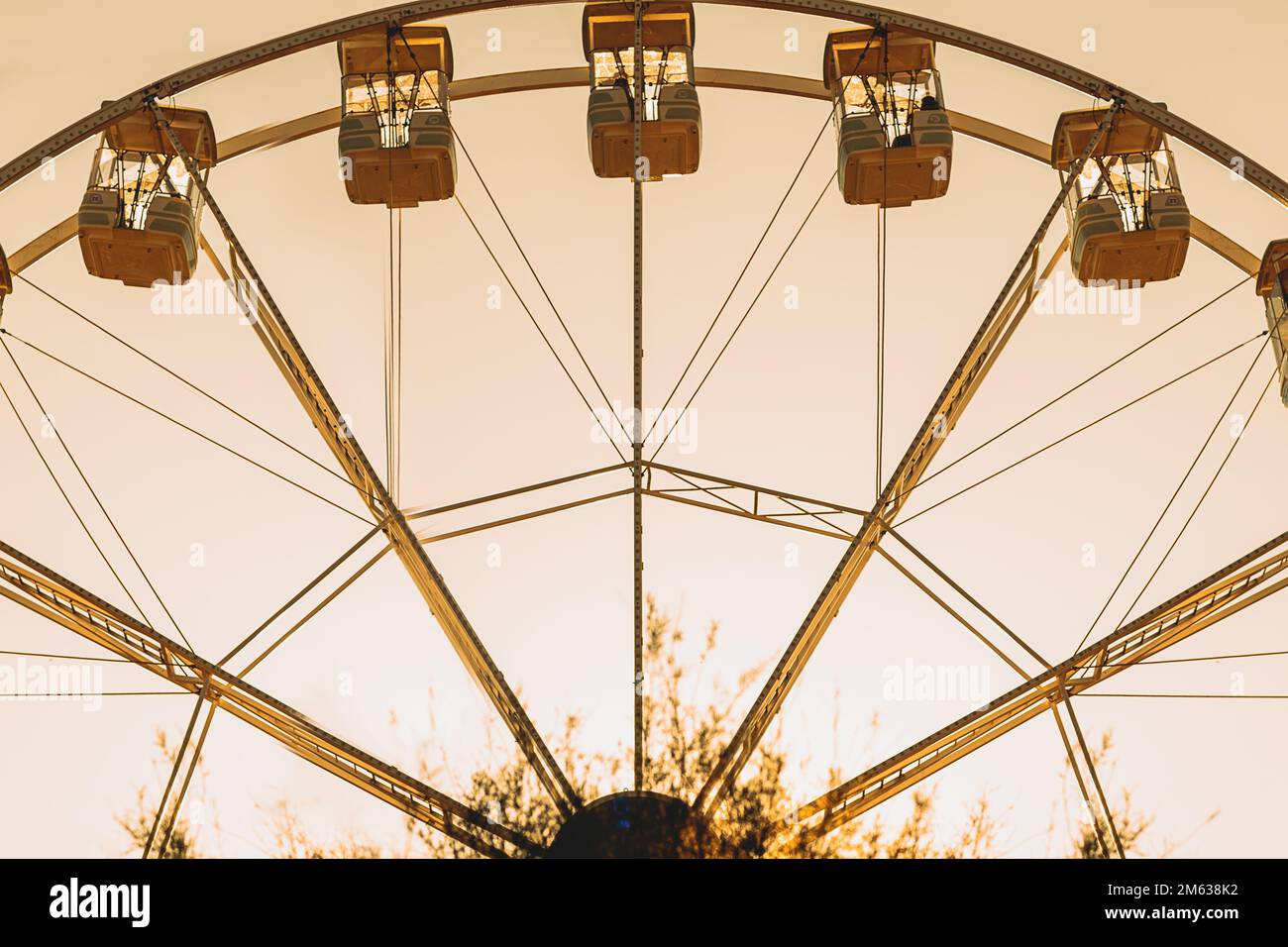 Angle bas de la roue de Ferris avec des gondoles situées contre le ciel de coucher de soleil sans nuages sur le parc d'expositions de Donostia San Sebastian, Espagne Banque D'Images