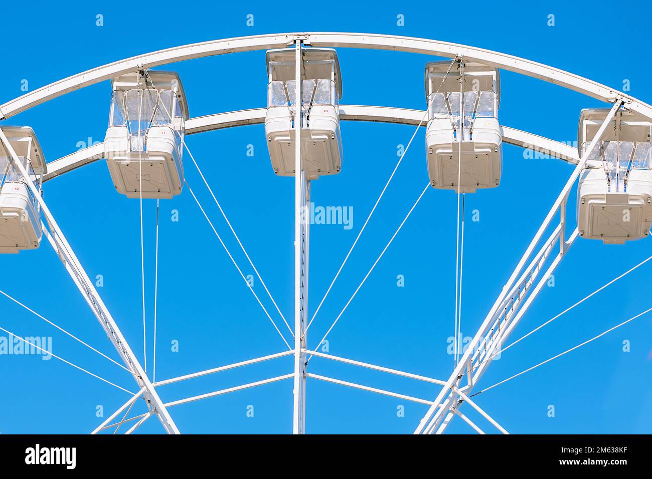 Angle bas de la roue Ferris avec gondoles situées contre un ciel bleu clair et sans nuages sur le parc d'expositions de Donostia San Sebastian, Espagne Banque D'Images
