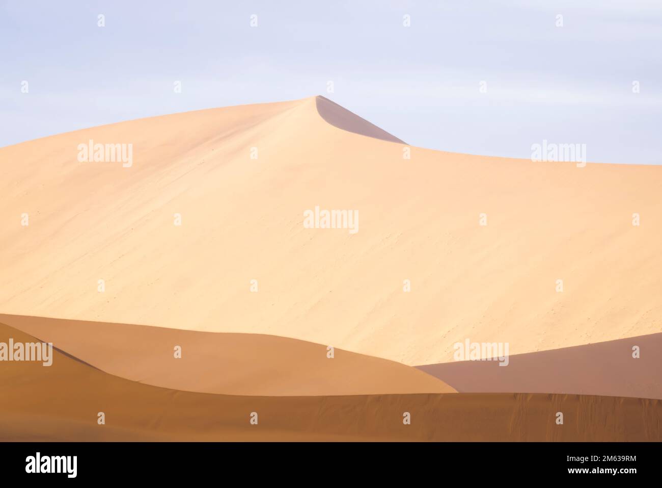 Paysage abstrait de magnifiques dunes de sable de terre désertique dans la lumière douce et chaude du soleil avec ciel clair Banque D'Images