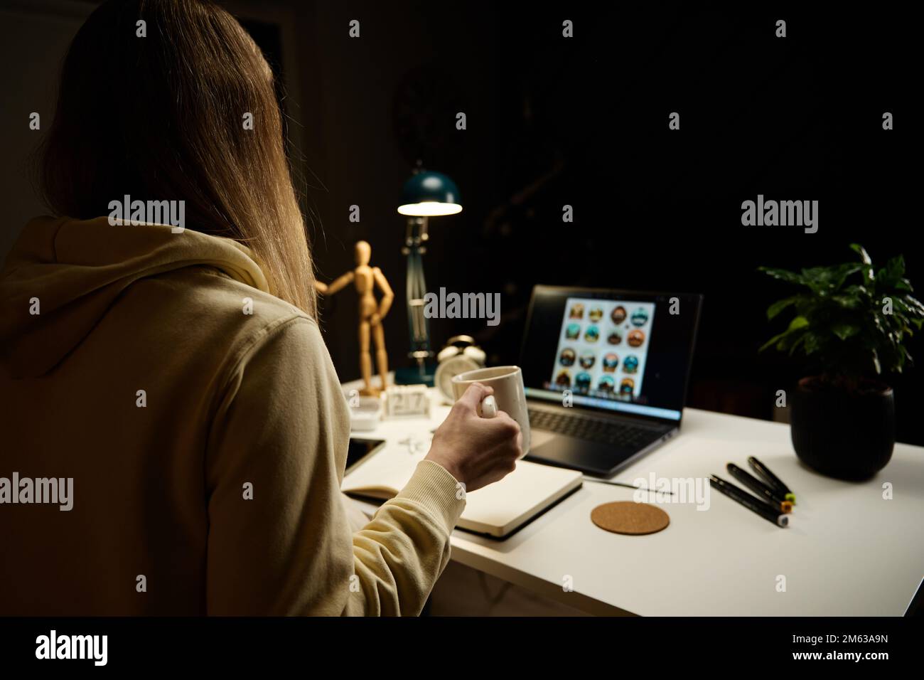 Elle travaille tard sur son lieu de travail à domicile. Femme indépendante portant un casque à l'aide d'un ordinateur portable dans le salon la nuit Banque D'Images