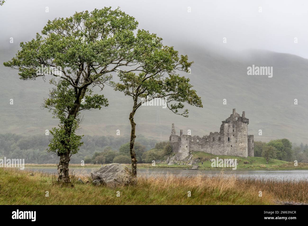 Château de Kilchurn, Loch Awe, Écosse, par une matinée brumeuse avec une eau calme et une lumière atmosphérique douce créant une scène paisible des Highlands. Banque D'Images
