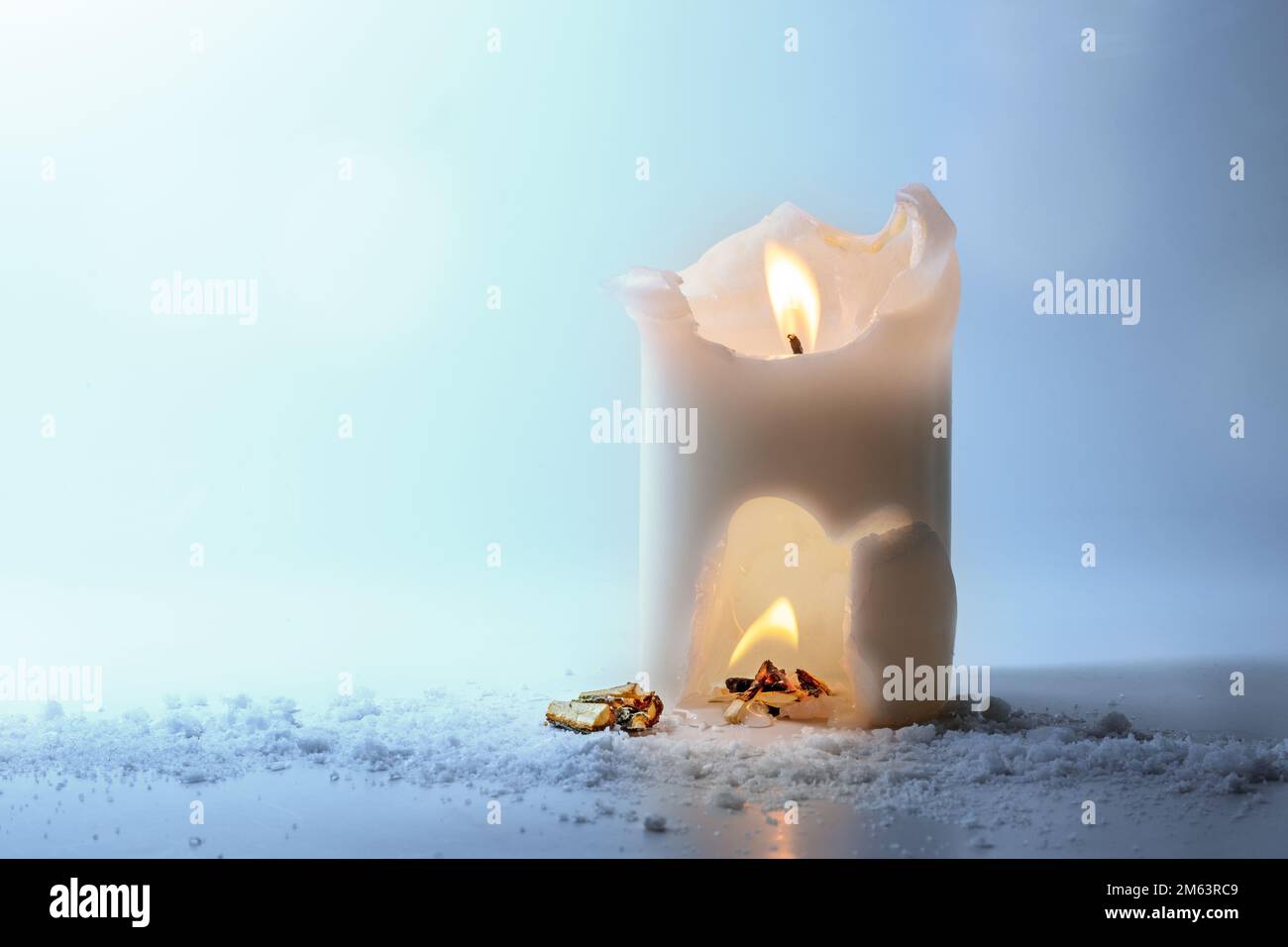 Bougie blanche brûlante avec une flamme, feu de camp dans une crique et feu de bois à l'extérieur, concept surréaliste pour la chaleur et l'énergie à la maison, vacances d'hiver encore la vie, Banque D'Images