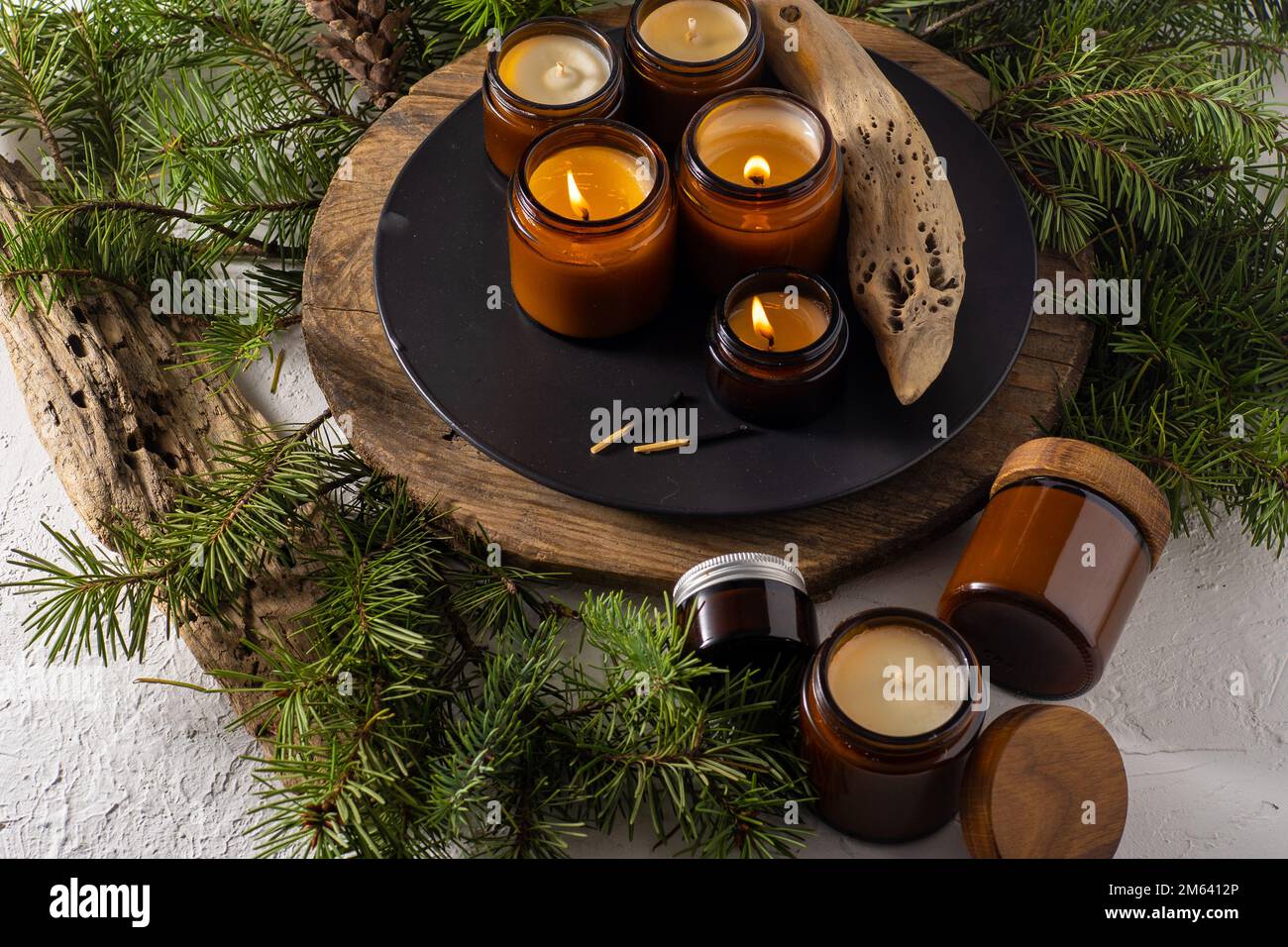Les bougies de soja brûlent dans des pots en verre. Confort à la maison. Bougie dans un pot brun. Parfum et lumière. Bougie parfumée faite à la main. Aromathérapie. Arbre de Noël et ambiance d'hiver. Décoration chaleureuse. Décoration de fête Banque D'Images