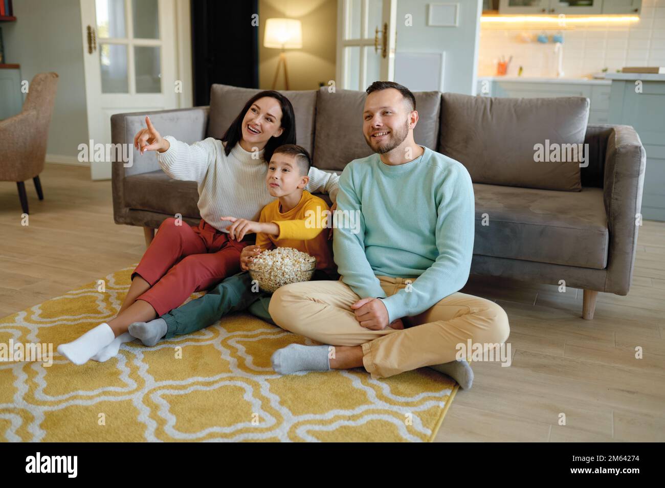 Des parents étonnés et des enfants curieux regardant un programme tv à la maison Banque D'Images