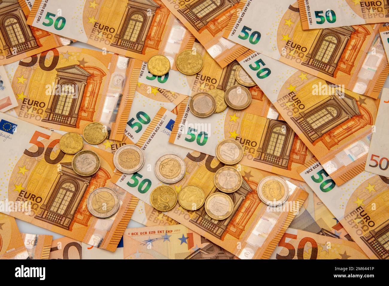 les billets de cinquante euros dispersés dans tout le cadre comme fond con varie monete di euro, concept financier et textures modèles Banque D'Images