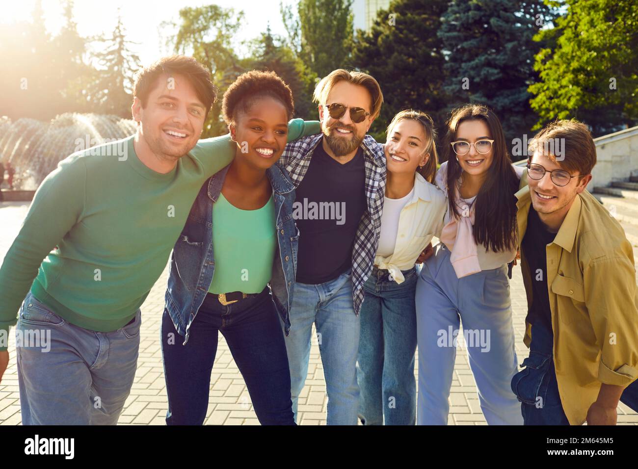 Groupe de jeunes heureux et joyeux amis multiethniques qui s'embrasent et s'amusent ensemble Banque D'Images