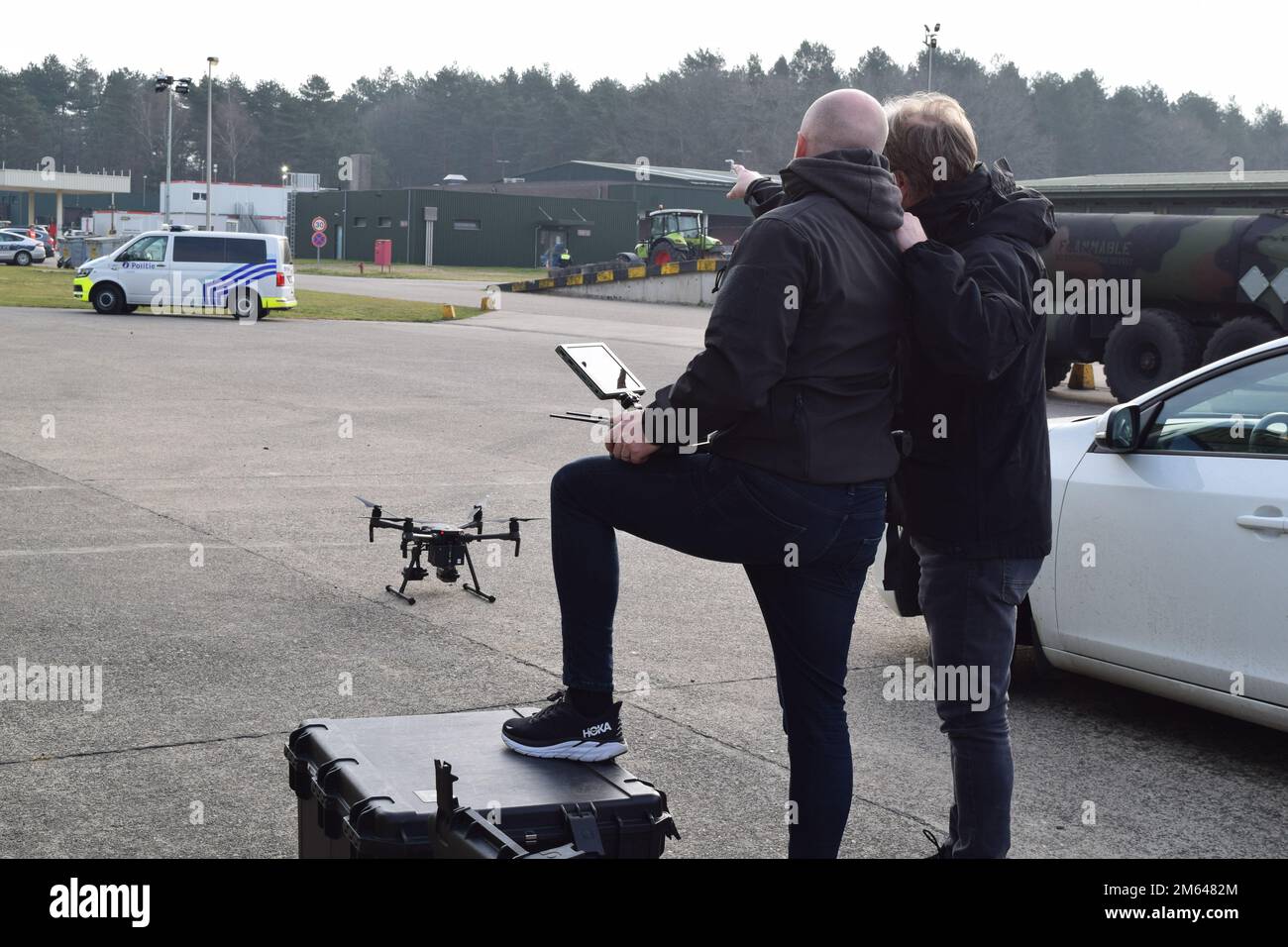Deux opérateurs de drones travaillant avec des intervenants d'urgence de la nation hôte belge parlent de la trajectoire de vol d'un drone au cours d'un exercice de protection de l'installation. Membres des États-Unis Garnison de l’armée l’équipe d’intervention d’urgence du Benelux s’est réunie avec des intervenants d’urgence belges pour effectuer un exercice de protection de l’installation au dépôt militaire de Zutendaal, en Belgique, au 30 mars. Le partenariat visait à évaluer le temps de réponse et les efforts de coordination entre les services d'urgence, tandis que les groupes jouaient le rôle de la découverte d'un dispositif explosif improvisé embarqué (VBIED) au dépôt, stationné près d'un réservoir de 100 000 litres Banque D'Images