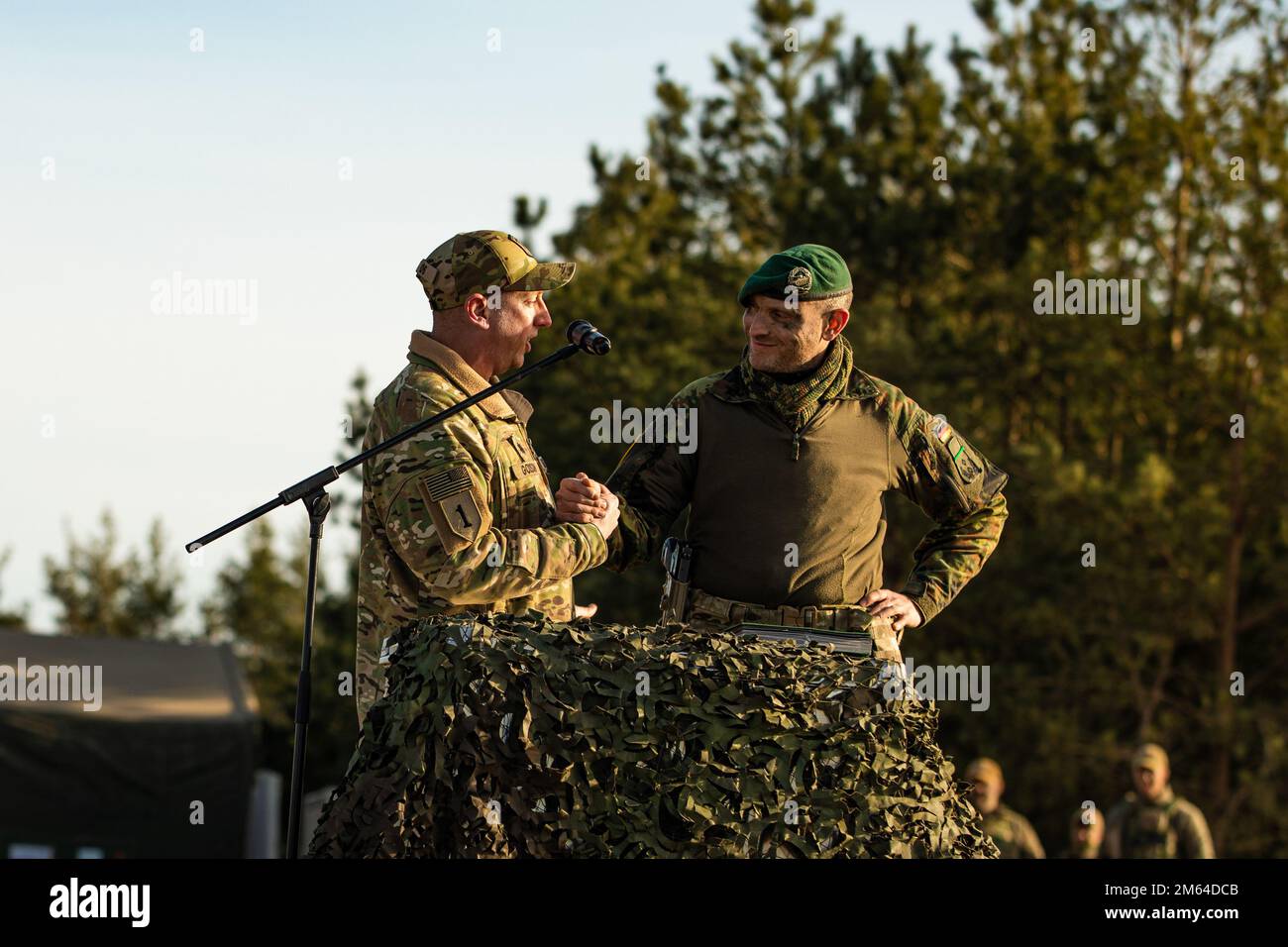 Le lieutenant-colonel Daniel Andrä, commandant du bataillon de la présence avancée renforcée de l'OTAN en Lituanie, Et le lieutenant-colonel Paul Godson, commandant du 3rd Bataillon, 66th Armored Regiment, 1st Infantry Division, se saluent lors d'une exposition statique tenue pour commencer l'exercice Rising Griffin à la zone d'entraînement de Pabrade, Lituanie, 31 mars 2022. Les membres de l'Alliance de l'Atlantique Nord qui ont participé à l'événement ont présenté certaines de leurs capacités de protection de la force pour rassurer leurs alliés de leur dévouement envers leur défense commune. Banque D'Images