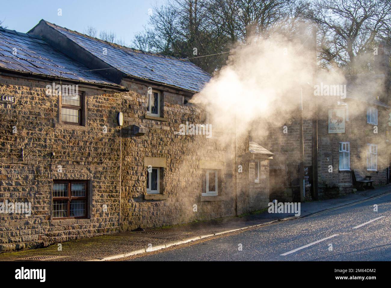 Limbrick, Lancashire. Météo Royaume-Uni. -3 C dans le nord-ouest comme le soleil bas tôt le matin met en évidence les émissions de vapeur de chauffage central de la propriété résidentielle de long Lane. Les chaudières produisent de longs panaches de vapeur avec l'humidité de l'air qui jouent également un rôle important dans les processus de condensation. Les gaz de combustion entrent en contact avec l'air humide froid, puis commencent à produire de longs panaches de minuscules gouttelettes d'eau. Crédit : MediaWorldImages/AlamyLiveNews Banque D'Images