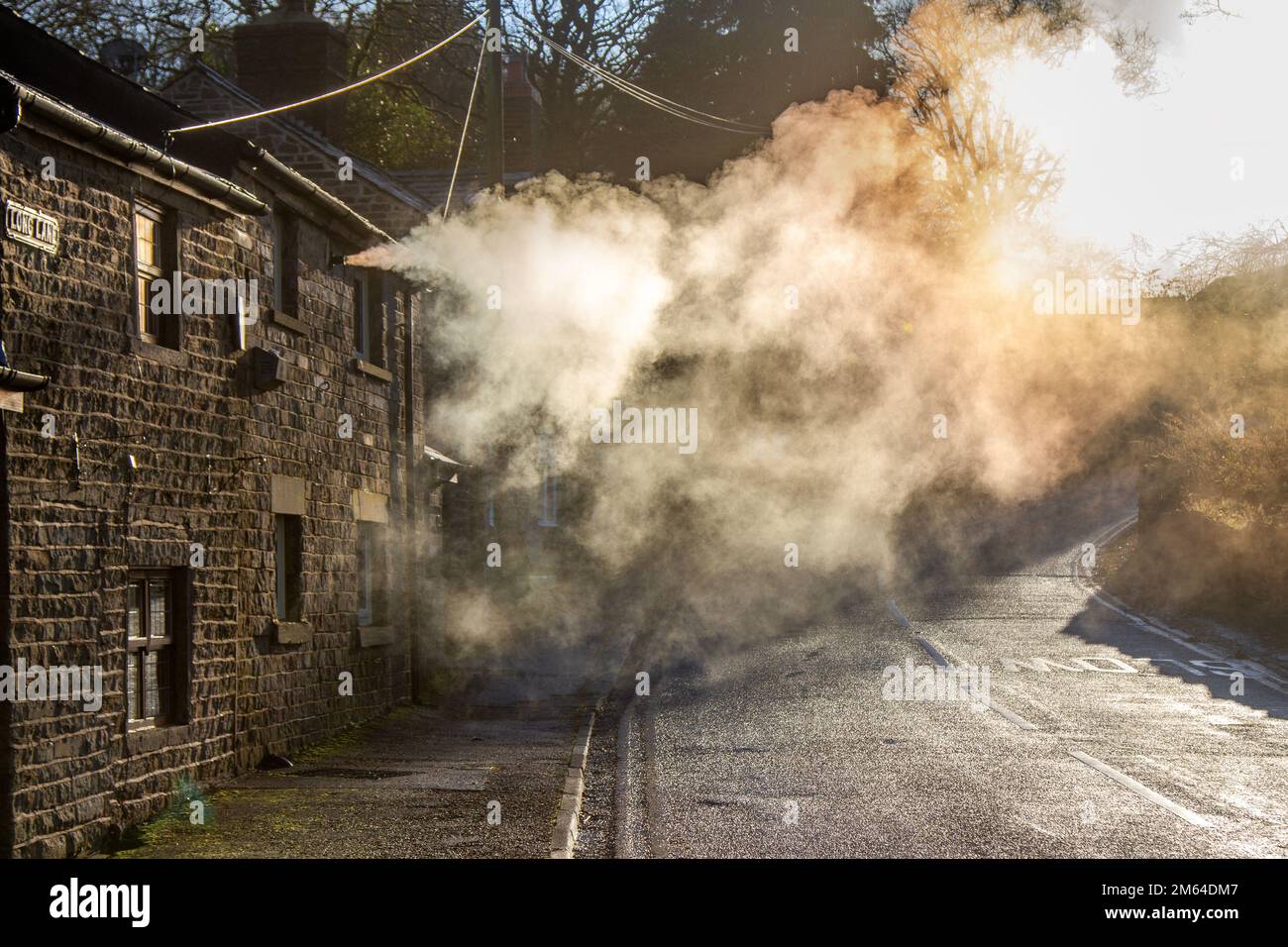 Limbrick, Lancashire. Météo Royaume-Uni. -3 C dans le nord-ouest comme le soleil bas tôt le matin met en évidence les émissions de vapeur de chauffage central de la propriété résidentielle de long Lane. Les chaudières produisent de longs panaches de vapeur avec l'humidité de l'air qui jouent également un rôle important dans les processus de condensation. Les gaz de combustion entrent en contact avec l'air humide froid, puis commencent à produire de longs panaches de minuscules gouttelettes d'eau. Crédit : MediaWorldImages/AlamyLiveNews Banque D'Images