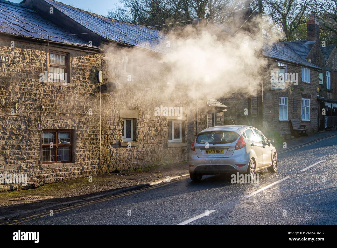 Limbrick, Lancashire. Météo Royaume-Uni. -3 C dans le nord-ouest comme le soleil bas tôt le matin met en évidence les émissions de vapeur de chauffage central de la propriété résidentielle de long Lane. Les chaudières produisent de longs panaches de vapeur avec l'humidité de l'air qui jouent également un rôle important dans les processus de condensation. Les gaz de combustion entrent en contact avec l'air humide froid, puis commencent à produire de longs panaches de minuscules gouttelettes d'eau. Crédit : MediaWorldImages/AlamyLiveNews Banque D'Images