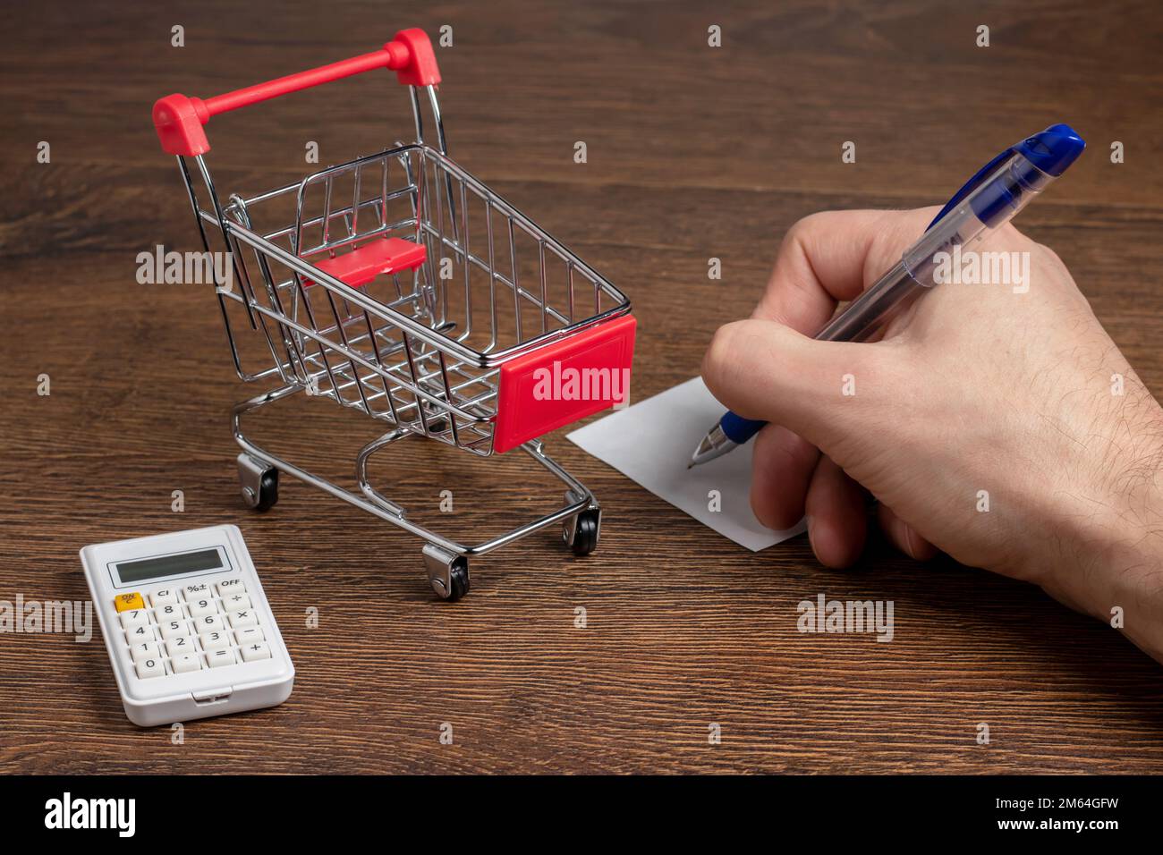 Man calcule le budget. Panier a sur table avec calculatrice et papier. Budget de la famille pauvre et à faible revenu. Magasin de produits alimentaires et d'épicerie pri Banque D'Images