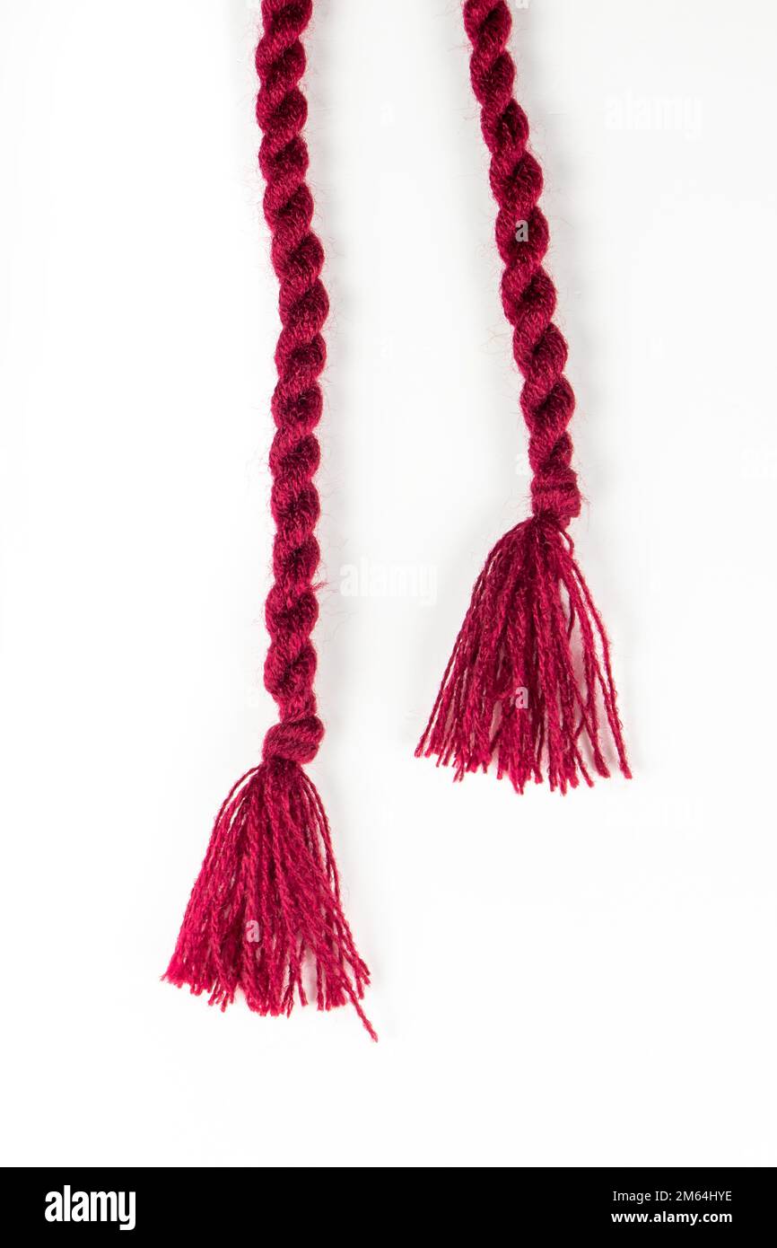 Franges en Bourgogne pour une robe tricotée sur fond blanc. Banque D'Images