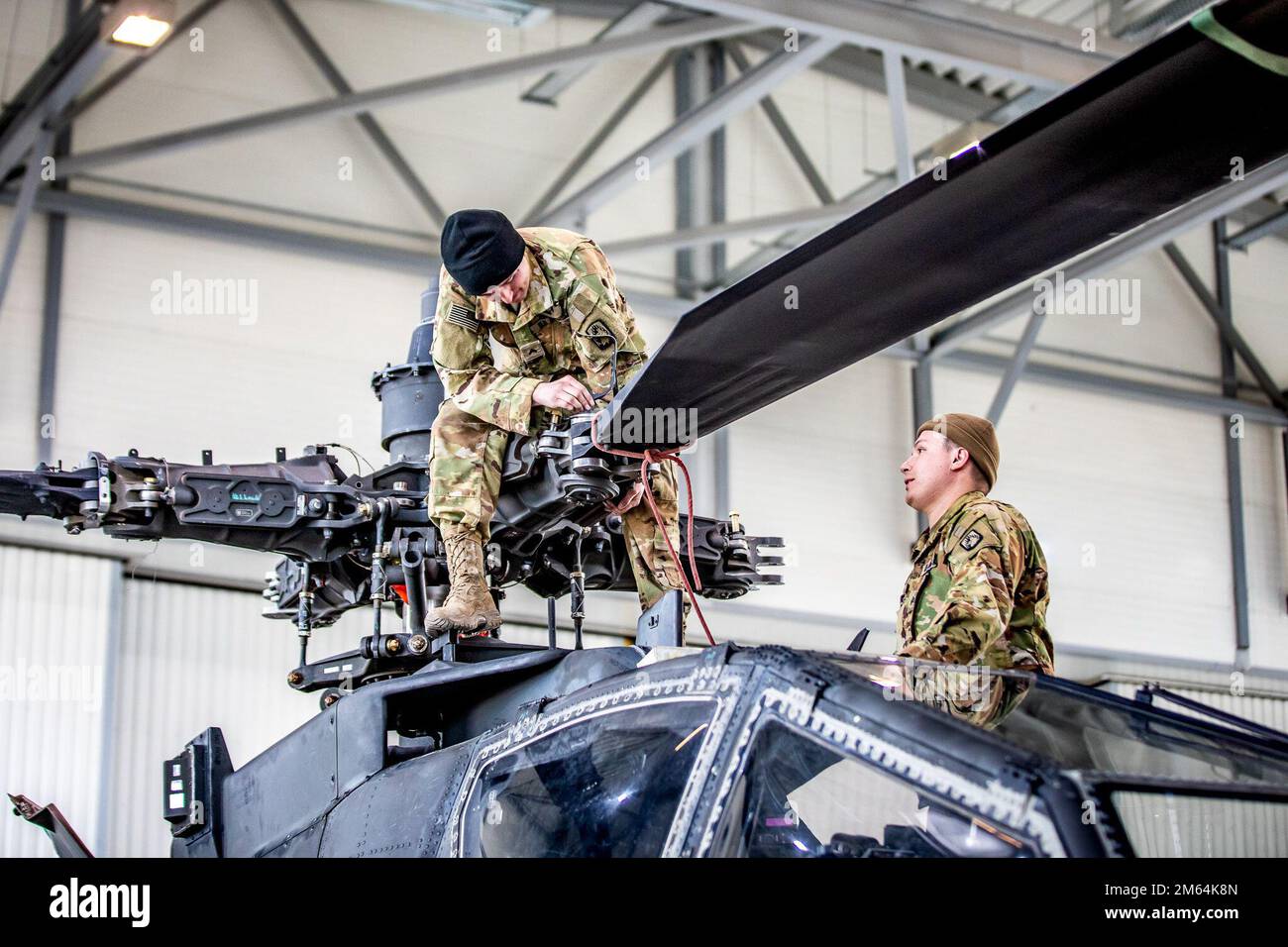 ÉTATS-UNIS Le Sgt Miclo Gutierrez et le Cpl Jeffery Robinson, réparateurs d'hélicoptères Apache, affectés à la Compagnie Charlie, 1-3rd Bataillon d'attaque, 12th Brigade de l'aviation de combat, installent une lame de tête de rotor principale sur un hélicoptère AH-64D Apache à la base aérienne de Lielvarde, en Lettonie, au 1 avril 2022. 12 L'ACR compte parmi les autres unités affectées au V corps, le Forward Deployed corps américain en Europe, qui travaille aux côtés des alliés de l'OTAN et des partenaires de sécurité régionaux pour fournir des forces prêtes au combat, exécuter des exercices d'entraînement conjoints et multinationaux, et conserve le commandement et le contrôle de toutes les unités permutantes et affectées dans l'Euro Banque D'Images