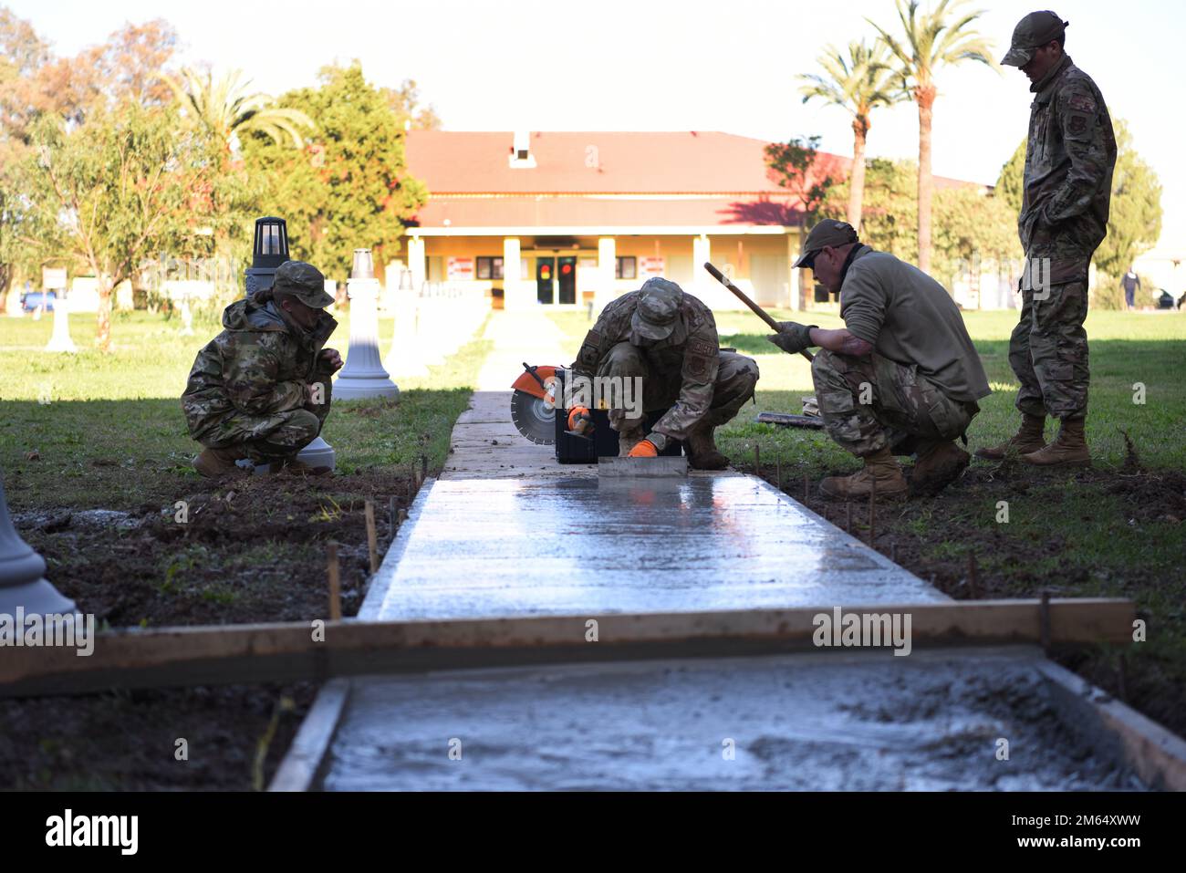 ÉTATS-UNIS Des aviateurs de la Force aérienne du niveau de l'escadron du génie civil 911th et lissent le béton qui a été versé pour réparer un trottoir sur la base aérienne de Morón, en Espagne, au 1 avril 2022. Les 911 ces de Pittsburgh, Pennsylvanie, ont récemment passé leur tournée annuelle de réserve à Morón AB où ils ont aidé la boutique ce locale sur quelques projets majeurs. La SCÉ de 911 a été en mesure de terminer des projets qui n'auraient normalement pas été réalisés en raison de ressources et d'effectifs limités. Les réparations de trottoirs ont été l'un des nombreux emplois accomplis par le ces 911 au cours de leur séjour de deux semaines en Espagne. Parmi les autres tâches, il y avait la création d'une buanderie à Banque D'Images