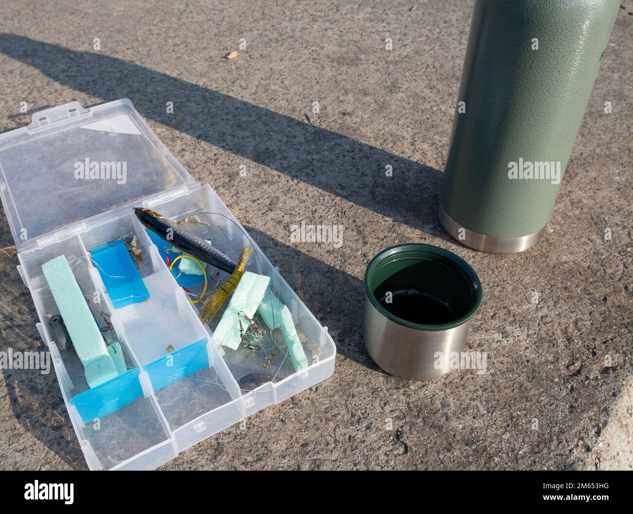 Kit de pêche et tasse à café et thermos. Concept d'équipement de pêche et de boisson chaude. Banque D'Images