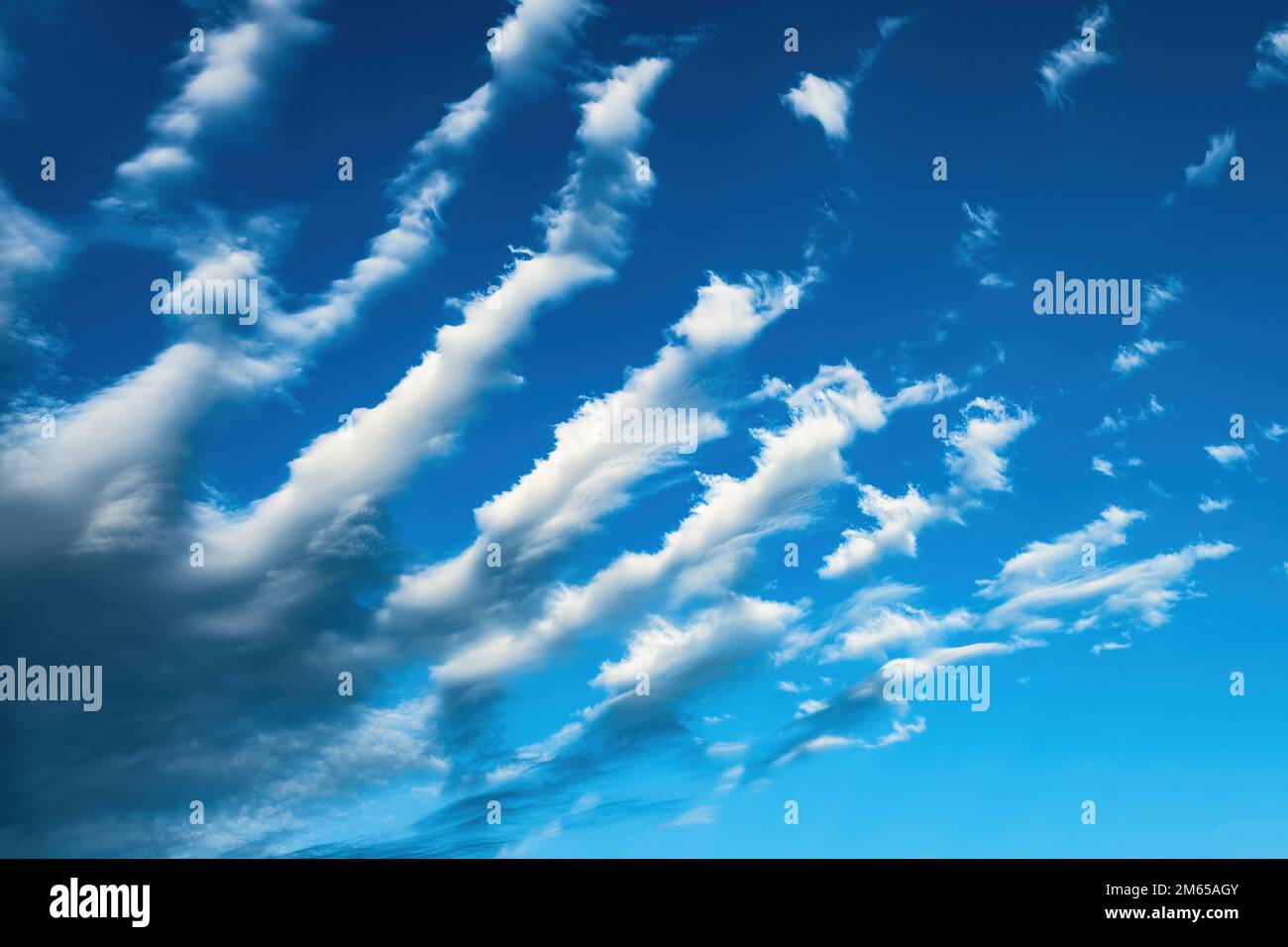 Des nuages de cirrus inhabituels formant des bandes parallèles dans le ciel bleu en été après-midi Banque D'Images
