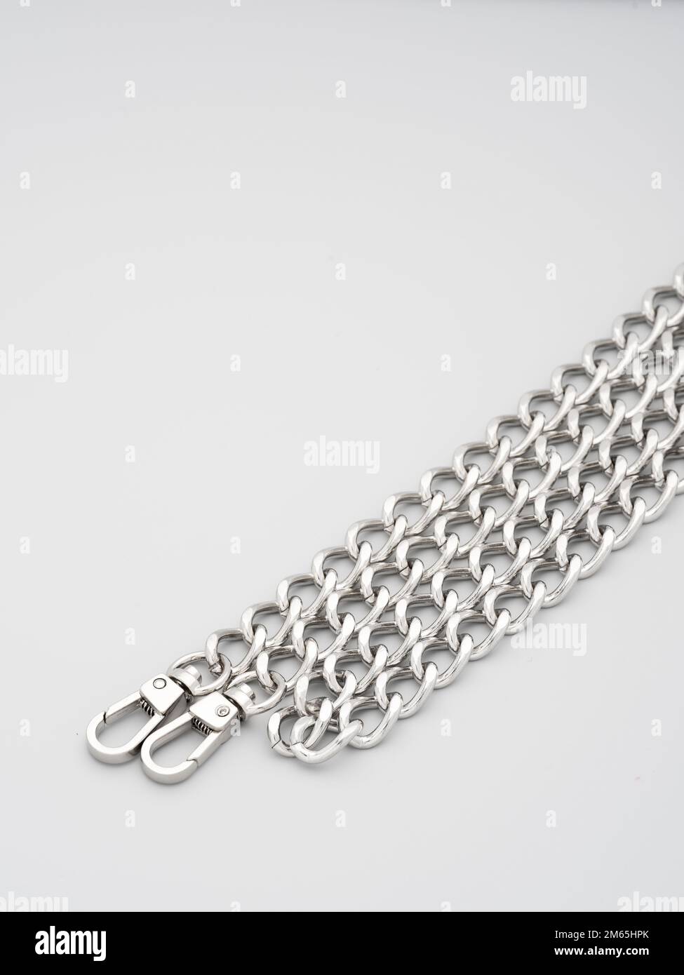 accessoires et fournitures pour chaînes métalliques pour sacs, sacs à dos et couture sur fond gris. Dispositifs de réglage en métal chromé pour sangles de sacs à main. Banque D'Images