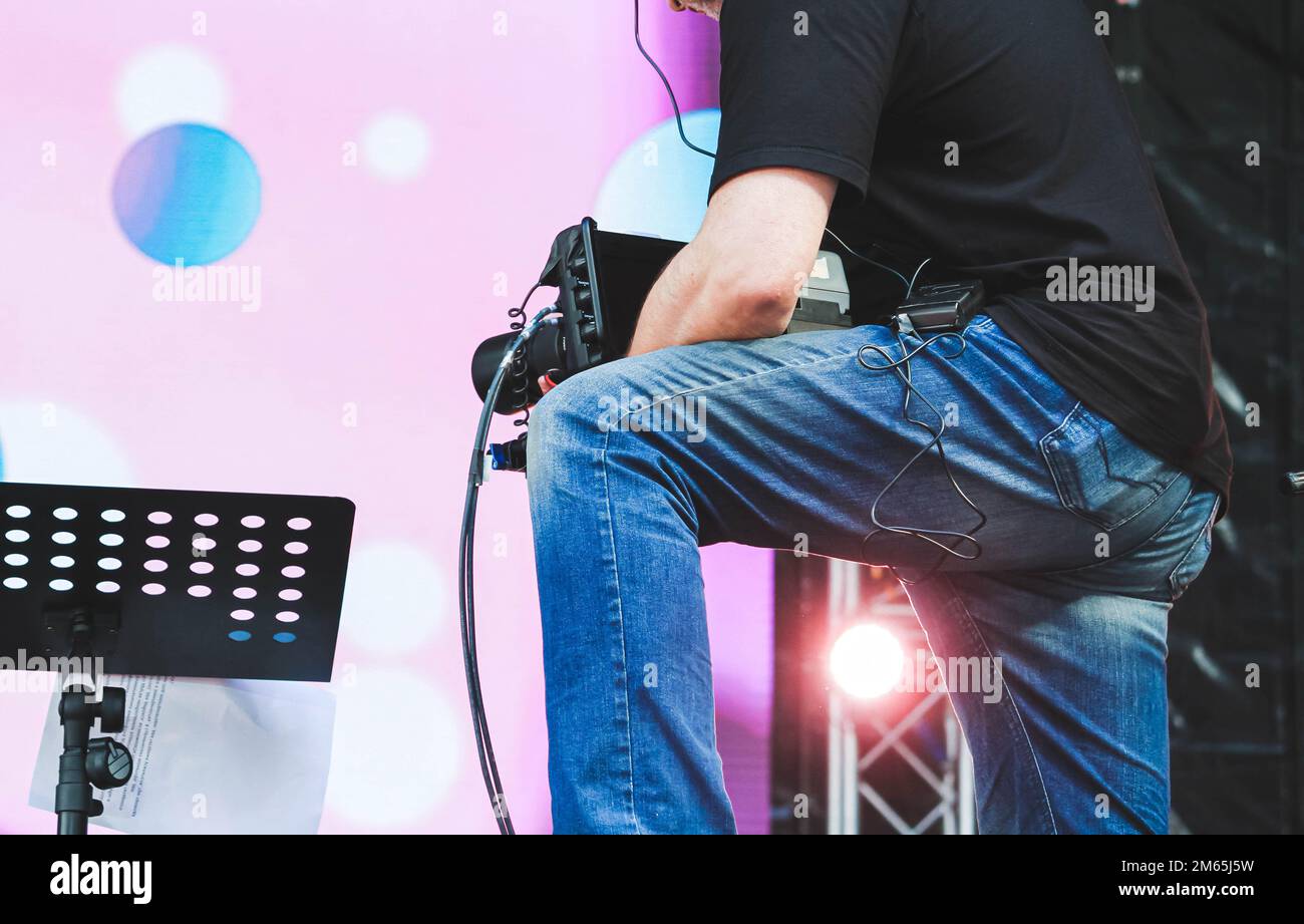 L'opérateur équipé d'une caméra vidéo enregistre un concert. Tournage de vidéos lors de l'événement... Banque D'Images