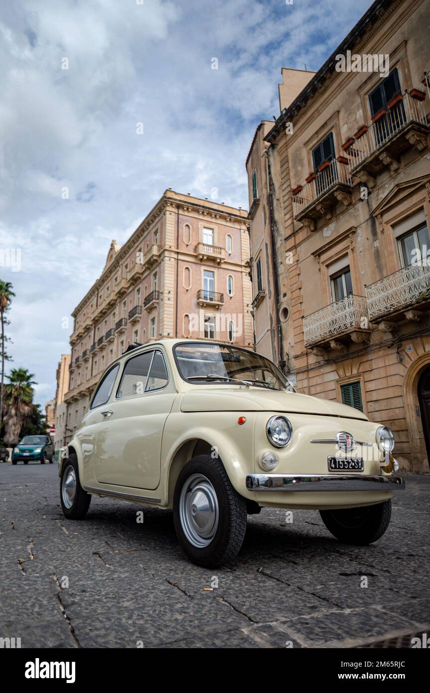 Un cliché vertical d'une automobile Fiat 500 couleur crème dans une rue de Syracuse, en Sicile Banque D'Images