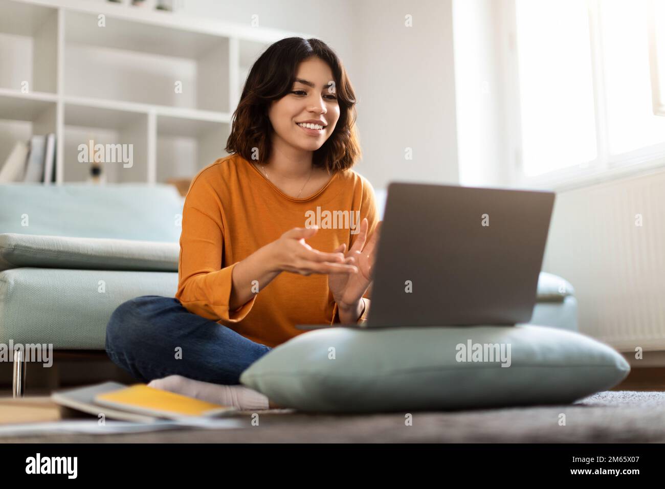 Téléconférence. Bonne jeune femme arabe qui fait des appels vidéo avec un ordinateur portable à la maison Banque D'Images