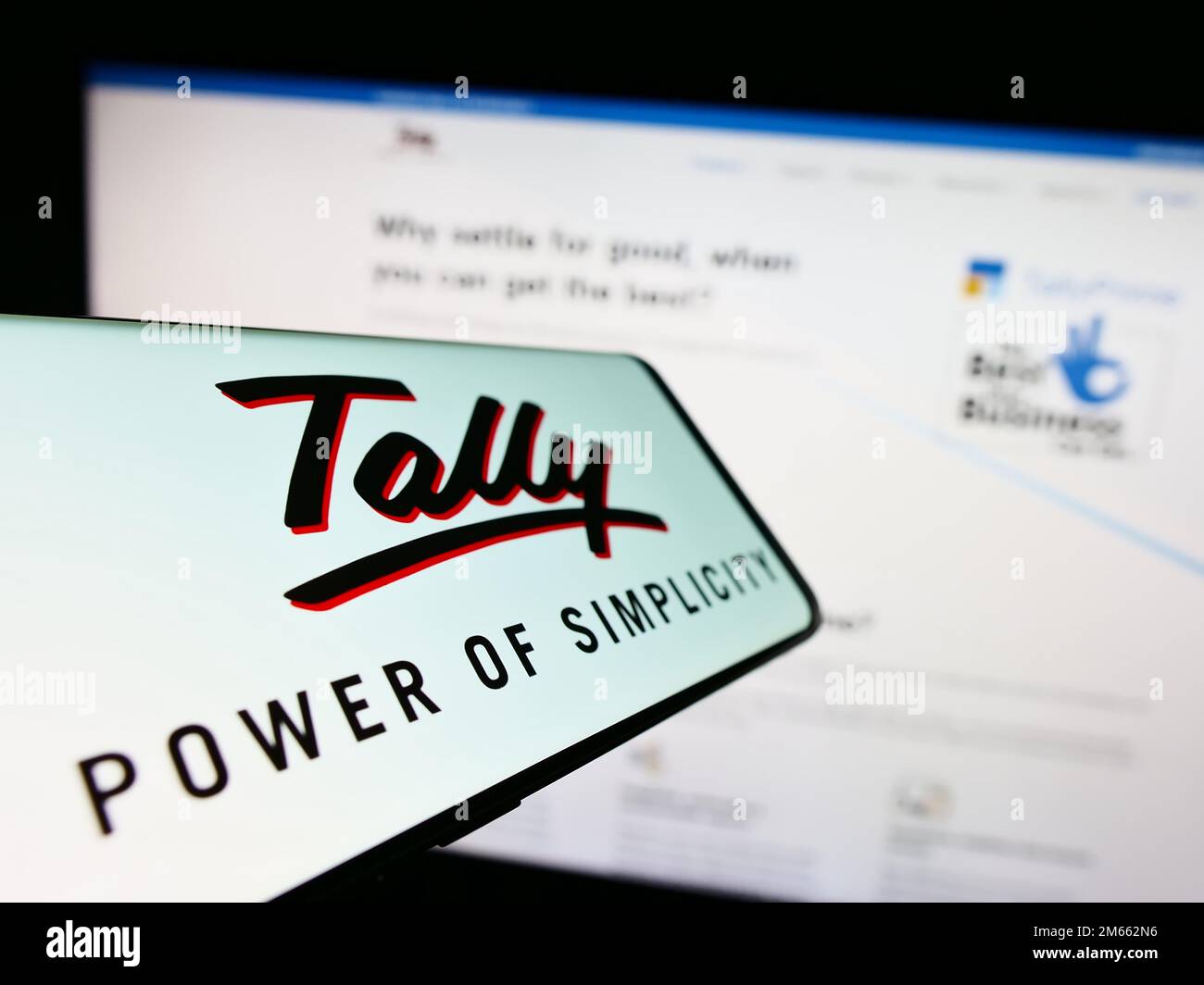 Smartphone avec logo de la société de logiciels Tally Solutions Pvt. Ltd. Sur écran devant le site Web d'affaires. Concentrez-vous sur le centre de l'écran du téléphone. Banque D'Images