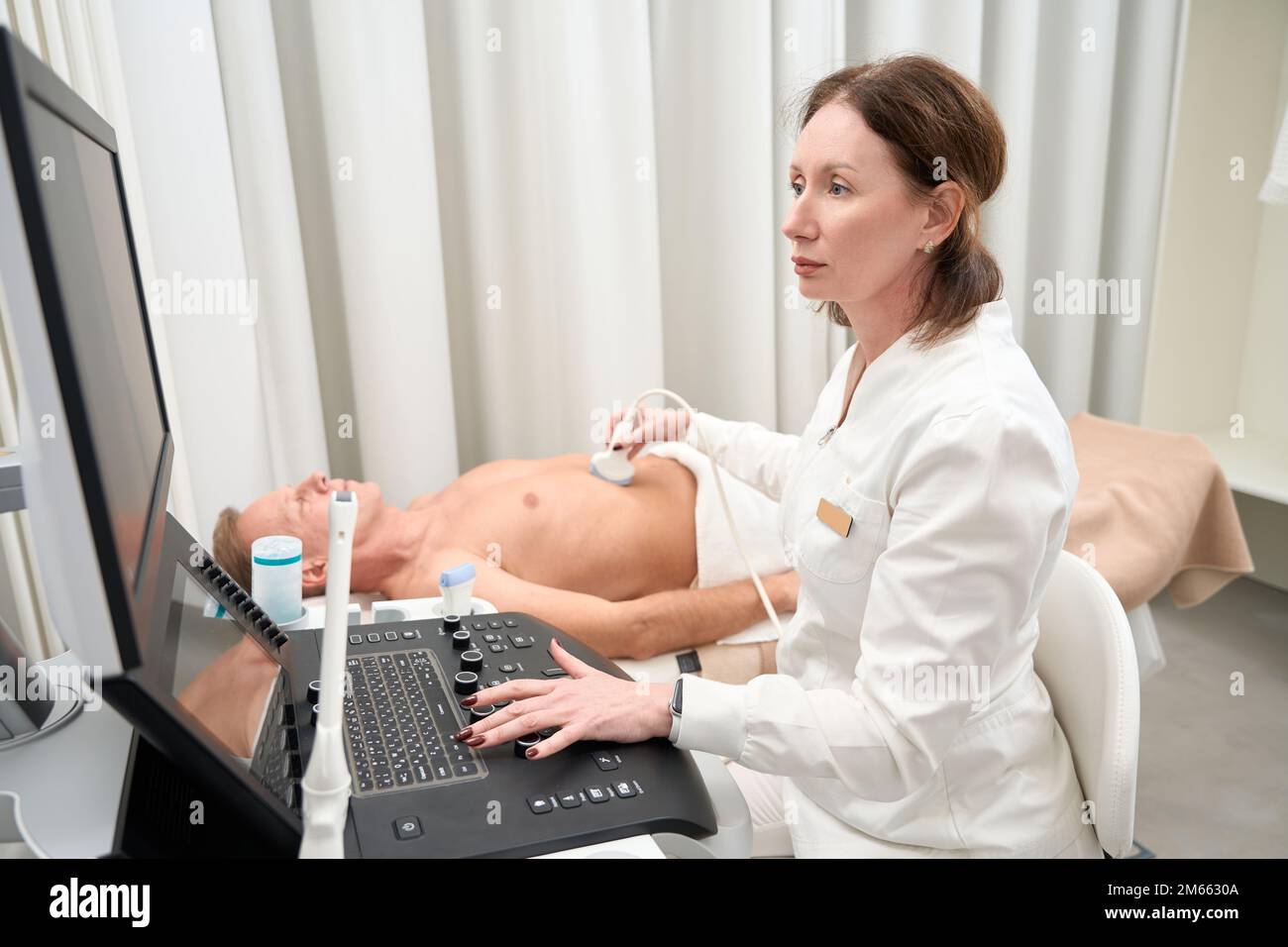 Un spécialiste en échographie effectue l'examen de la cavité abdominale à l'aide d'un appareil Banque D'Images
