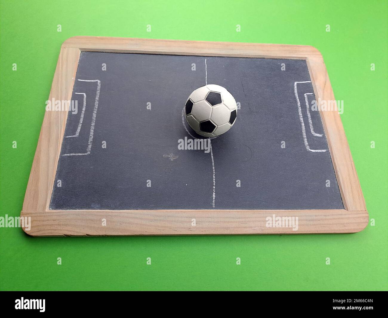 Illustration du terrain de football sur tableau noir, avec ballon. Vue latérale, arrière-plan vert Banque D'Images