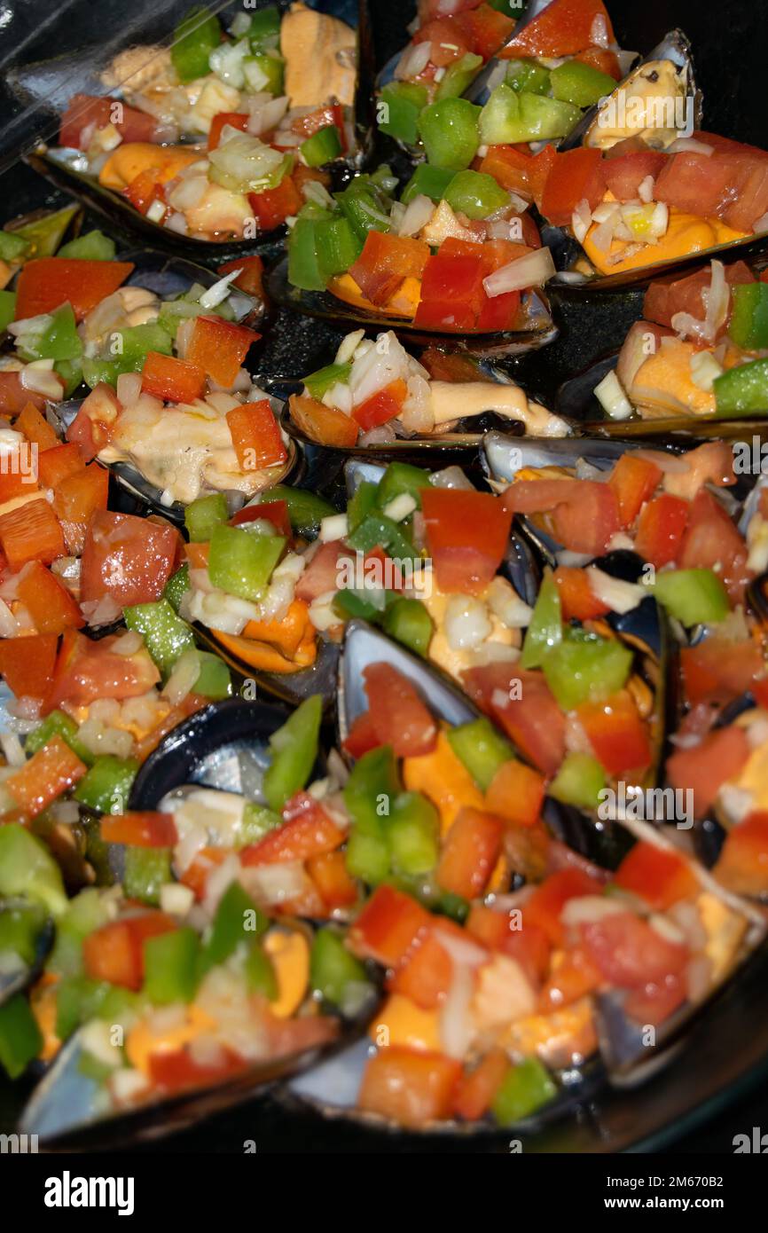 moules cuites farcies de poivrons rouges et verts et sauce au vinaigre. Fruits de mer, cuisine méditerranéenne ou recettes de cuisine. Banque D'Images