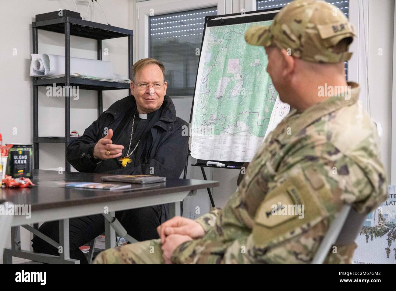 ÉTATS-UNIS Le lieutenant-colonel Paul Godson, commandant du 3rd Bataillon, 66th Armored Regiment, 1st Infantry Division, s'assoit et discute avec l'archevêque lituanien Gintaras Grušas au Camp Herkus, Lituanie, 12 avril 2022. Banque D'Images