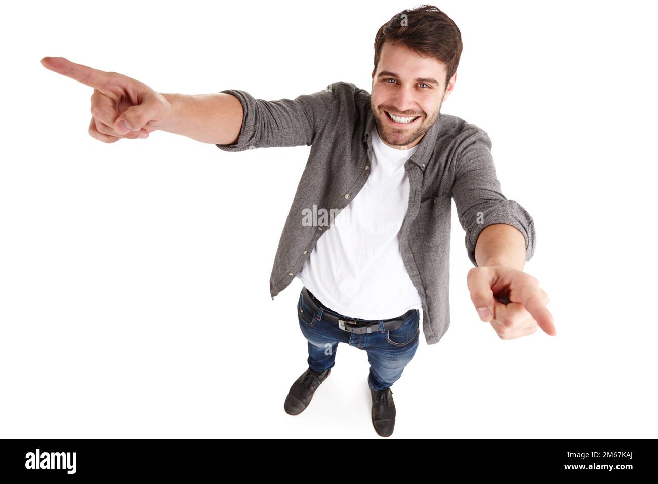 Partager la réussite. Photo en grand angle d'un jeune homme heureux dans un studio qui lève les bras et pointe. Banque D'Images