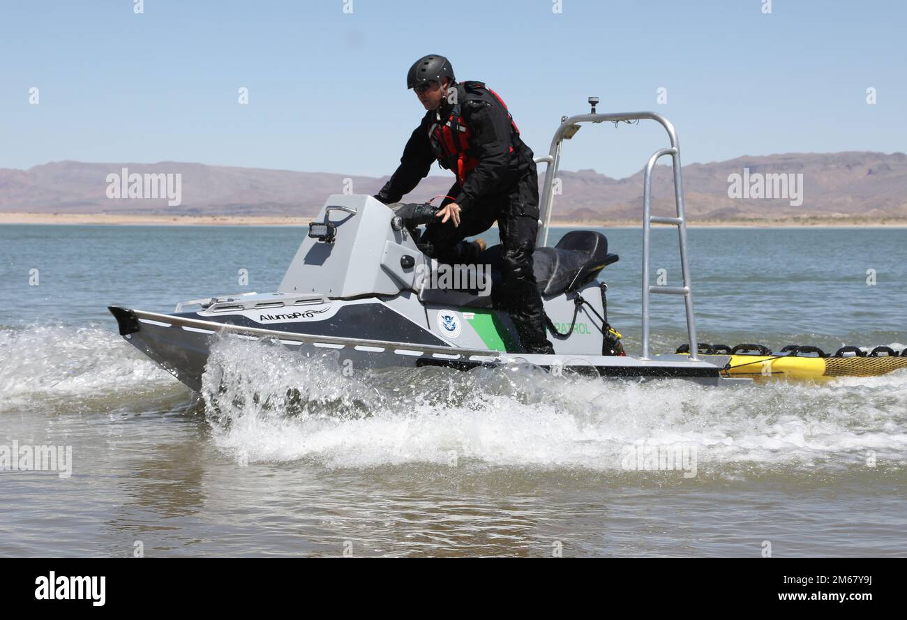 Un agent de patrouille frontalière se démonte d'une embarcation de sauvetage AlumaPro spécialement construite à l'approche du rivage tout en travaillant à l'appui d'un candidat qualification de natation pour les États-Unis Unité de recherche, de traumatologie et de sauvetage de la patrouille frontalière, également connue sous le nom de BORSTAR au parc national de Lake Elephant Butte, au Nouveau-Mexique, au 14 avril 2022. Les motomarines portent des vêtements américains La police des frontières et les États-Unis Les douanes et la protection des frontières. Les motomarines AlumaPro utilisées par Border Patrol ont été spécialisées pour le sauvetage de l'eau avec une coque en aluminium rigide, des barres d'appui sur le nez et une tour d'appui verticale. En outre, un sauvetage flexible remorqué Banque D'Images