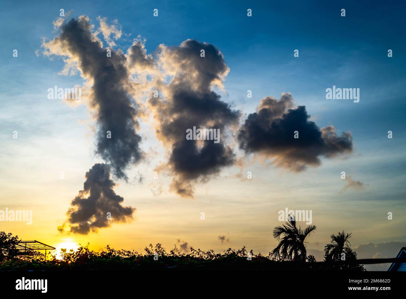 Art abstrait des nuages dans le ciel avec des bleus forts et des jaunes près du coucher du soleil. Banque D'Images