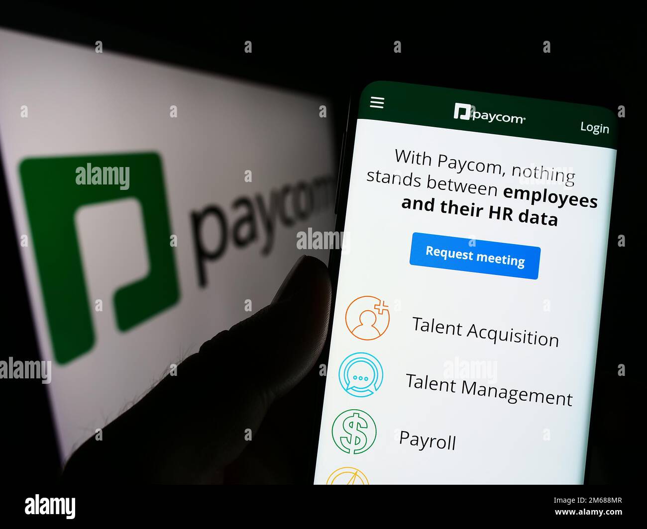 Personne tenant un smartphone avec la page Web de Paycom Software Inc., société de technologie de paie, à l'écran avec logo. Concentrez-vous sur le centre de l'écran du téléphone. Banque D'Images
