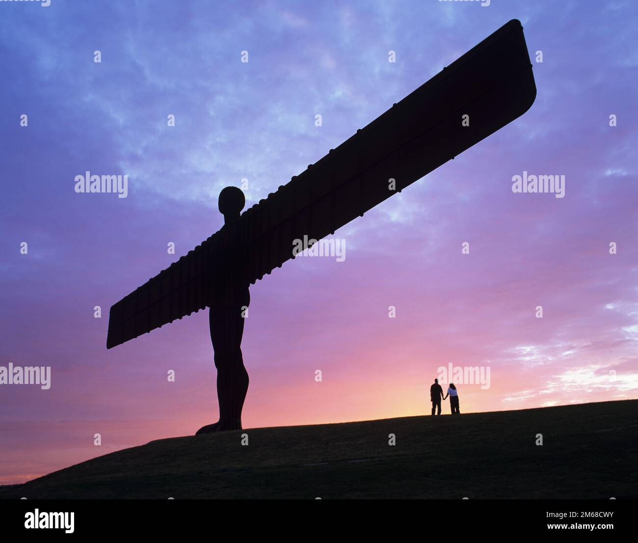 Un couple tient la main devant l'Ange du Nord à Gateshead, Tyne & Wear, Angleterre Banque D'Images