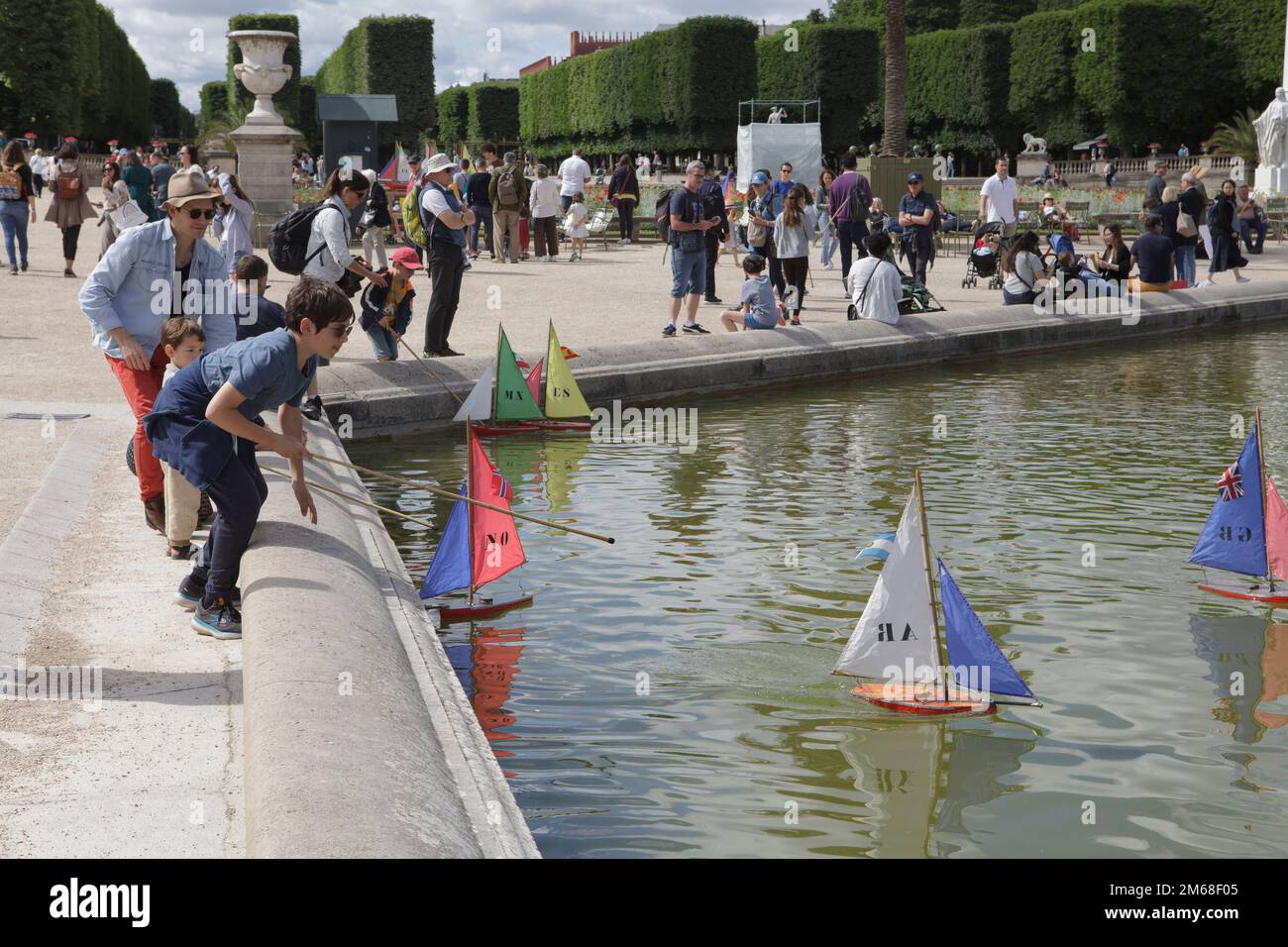 Les enfants naviguent en maquette sur le Grand bassin au jardin de Luxembourg à Paris, un jour d'été Banque D'Images