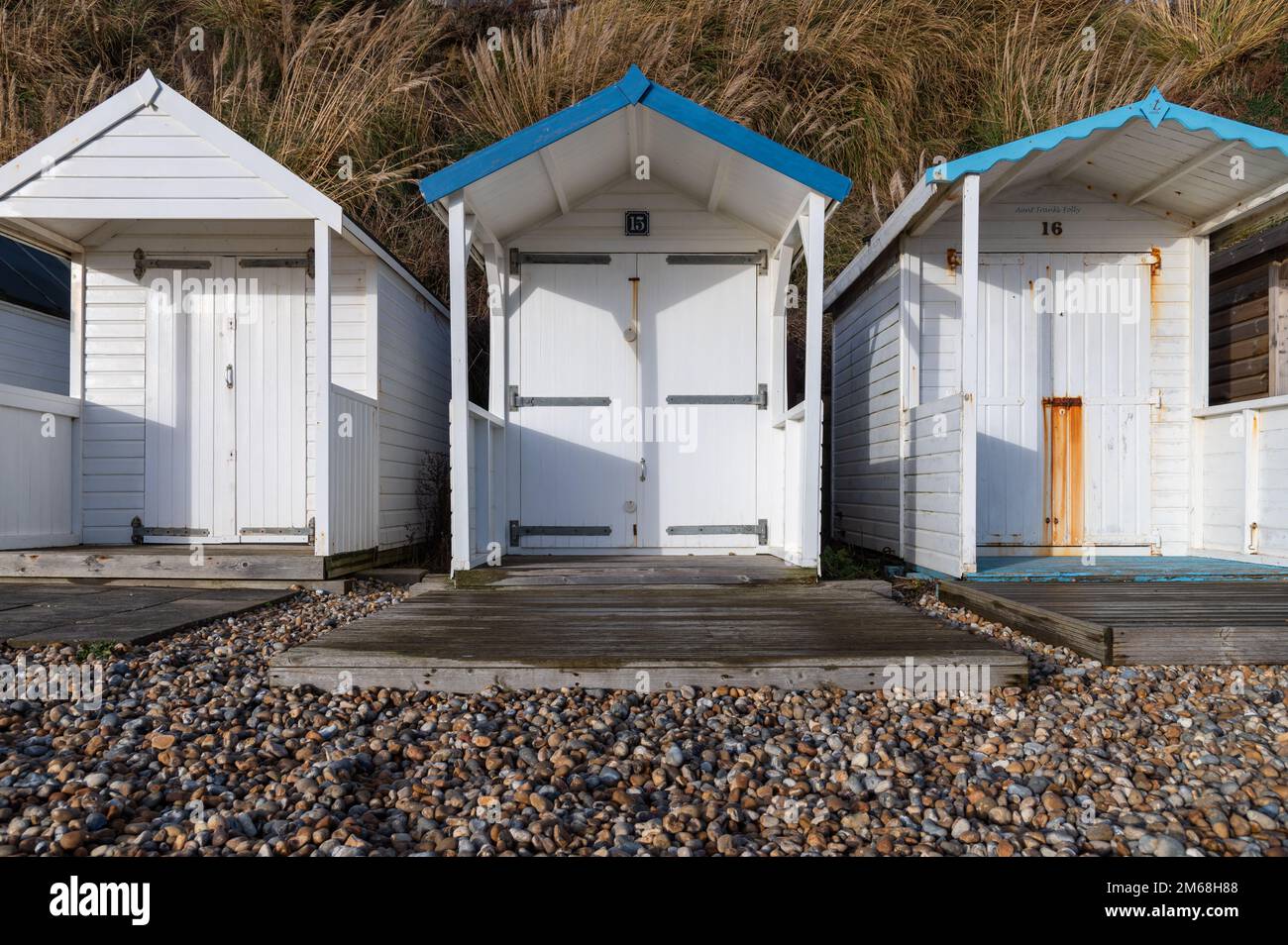 Trois cabanes de plage en bois blanc à Bexhill-sur-Mer par une journée ensoleillée Banque D'Images