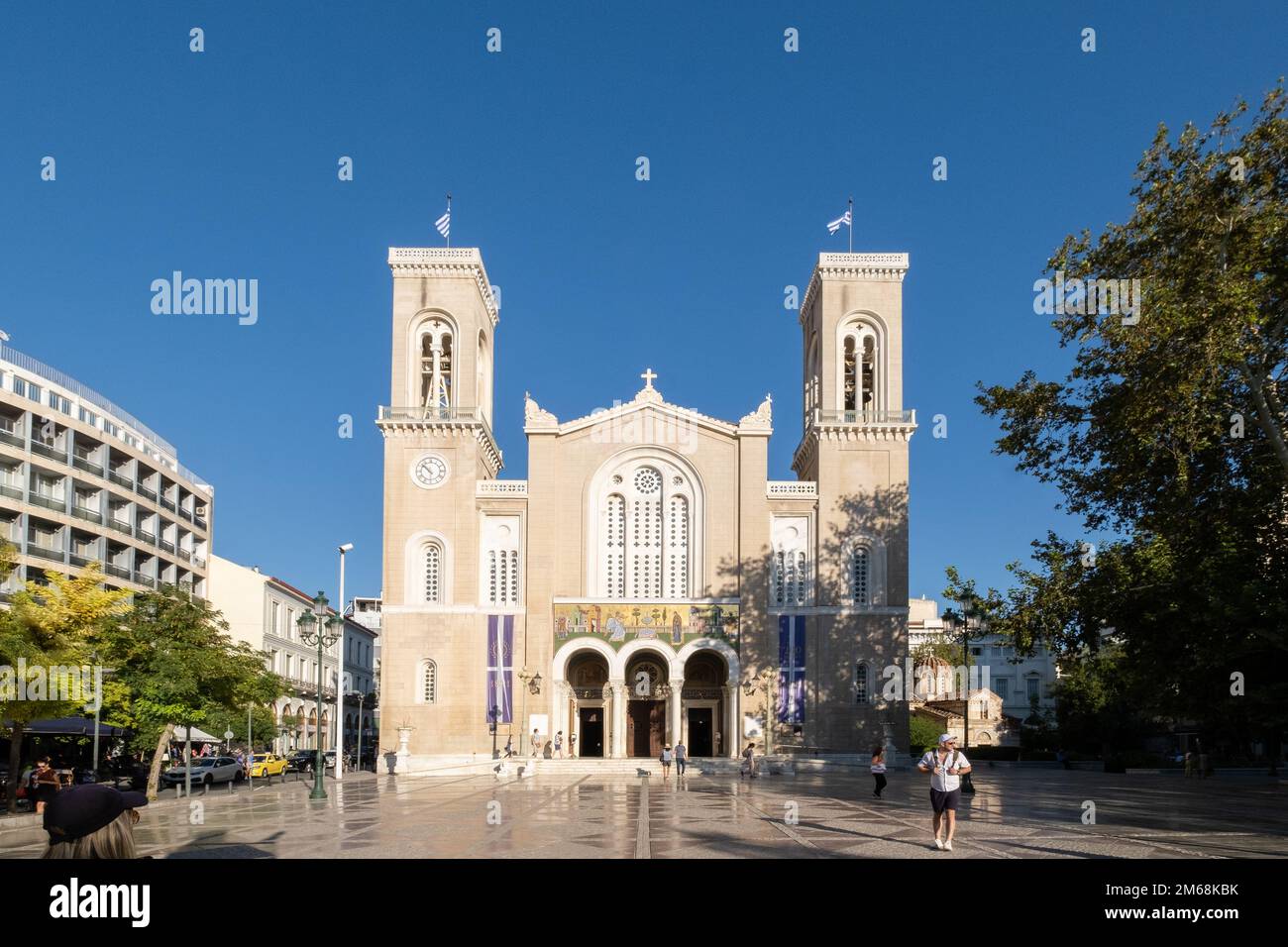 Cathédrale métropolitaine d'Athènes, Athènes, Grèce, un jour lumineux avec un ciel bleu profond au-dessus et quelques personnes marchant devant. Banque D'Images