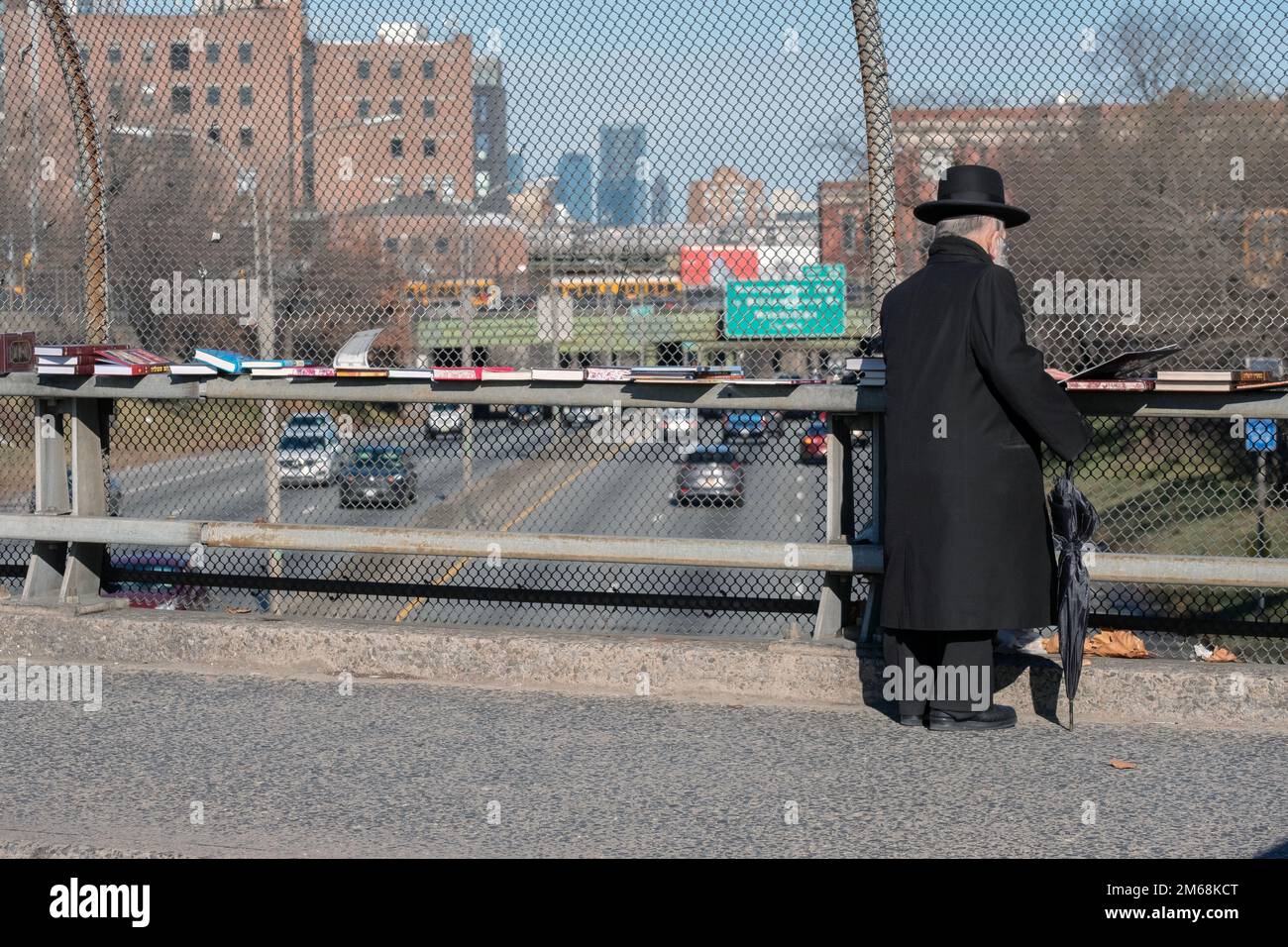 Un homme juif hassidique plus âgé fait ses courses pour des livres religieux lors d'une vente éclair sur le passage supérieur de BQE à Brooklyn, New York. Banque D'Images