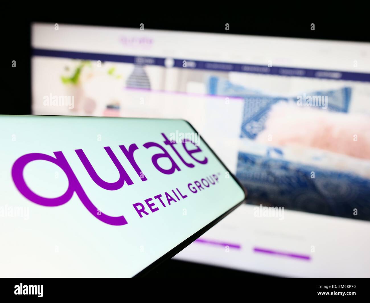 Smartphone avec le logo de la société américaine de médias Qurate Retail Inc. À l'écran devant le site Web d'affaires. Mise au point au centre-gauche de l'écran du téléphone. Banque D'Images