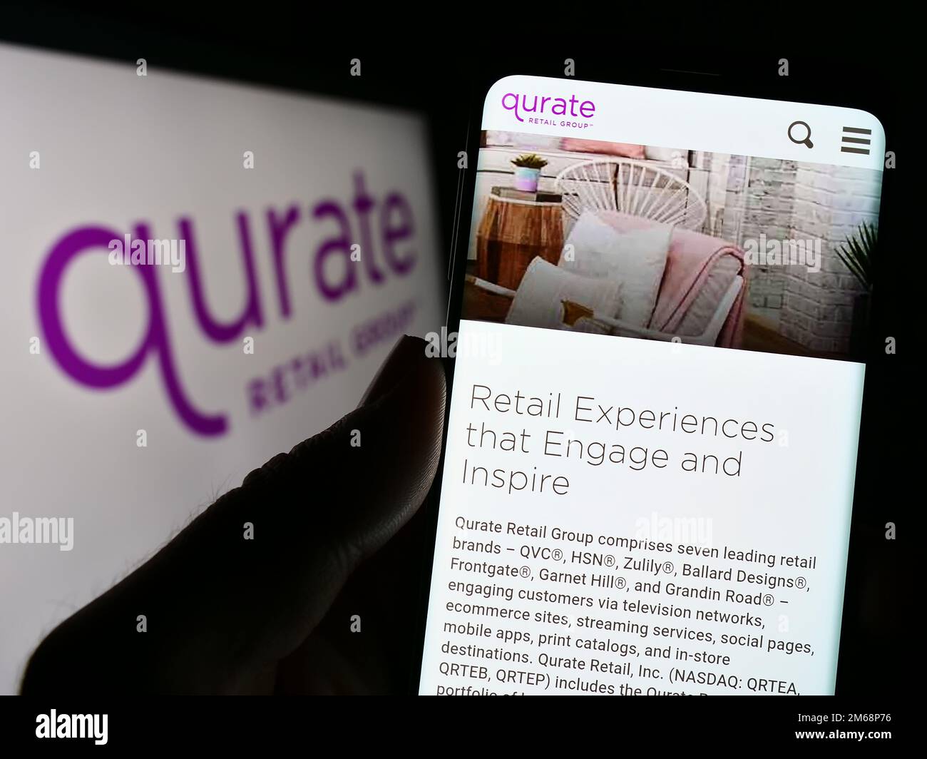 Personne tenant un téléphone cellulaire avec la page Web de la société de médias américaine Qurate Retail Inc. À l'écran devant le logo. Concentrez-vous sur le centre de l'écran du téléphone. Banque D'Images