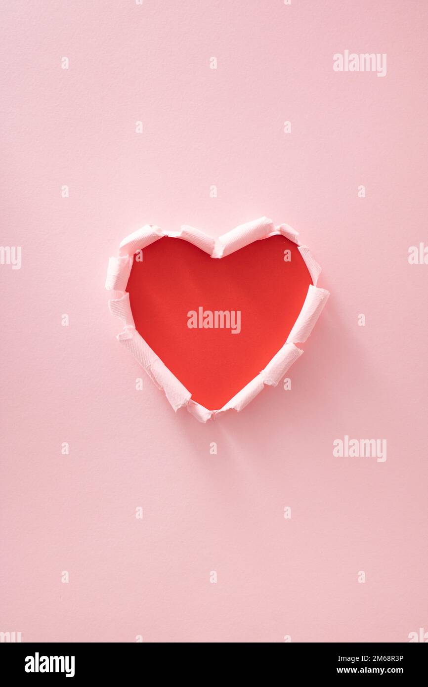 Cœur rouge en papier rose déchiré. Un minimum d'amour ou de valentine concept. Banque D'Images